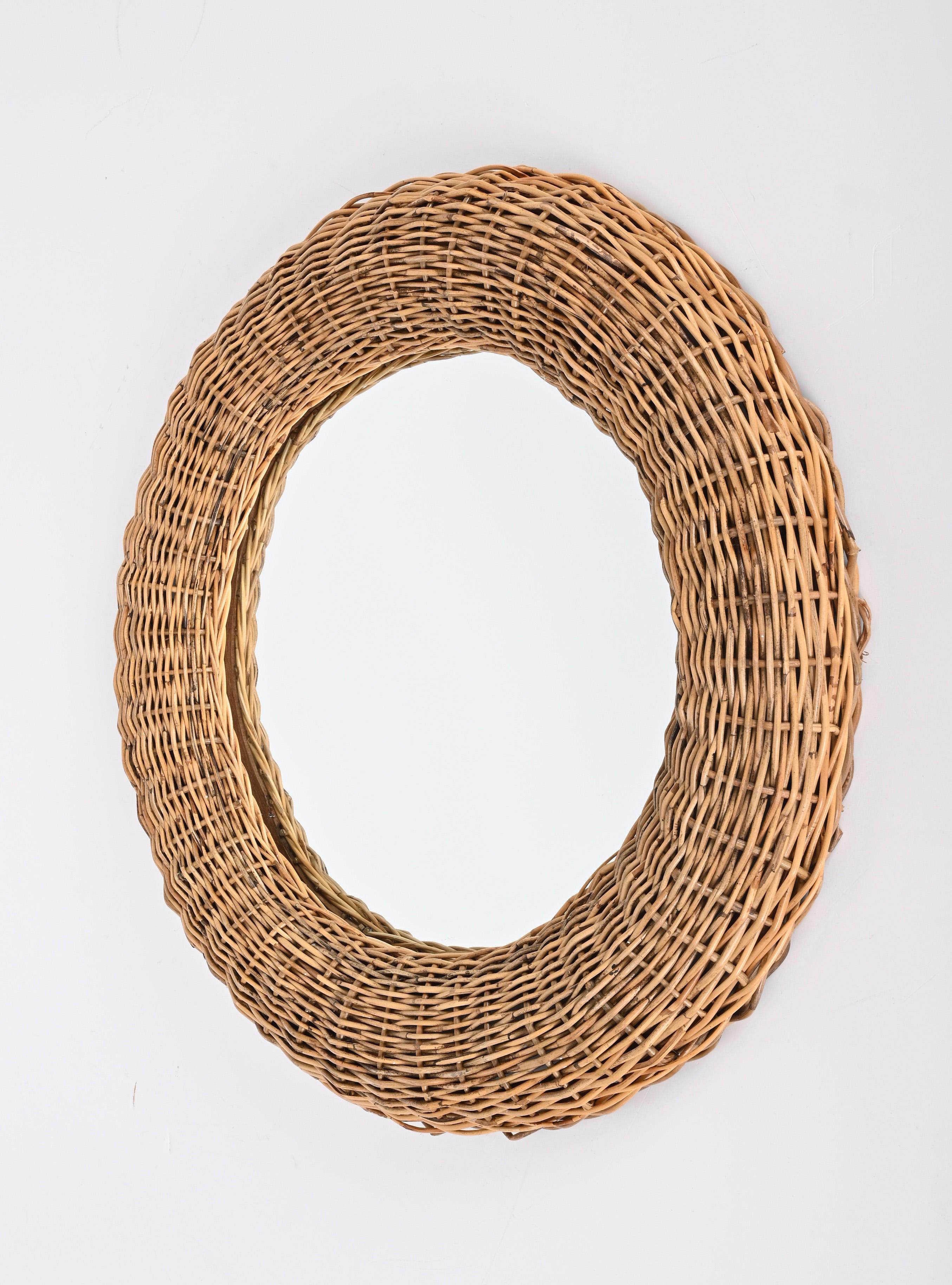 Amazing Mid-Century Modern wicker rattan round wall mirror. This fantastic piece was designed in Italy during the 1970s in the style of Franco Albini.

This item is wonderful as it is designed with rattan that is shaped in a round and perfect