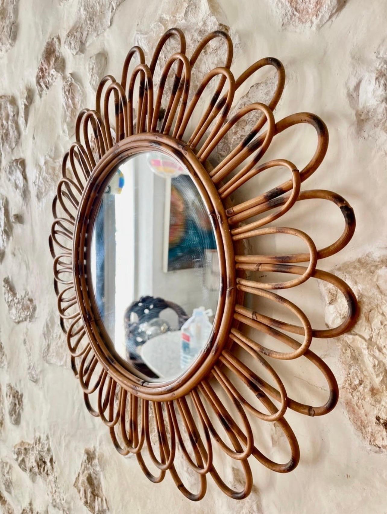 French Riviera round bamboo and rattan mirror with scrolling detail around the frame. Mediterranean, circa 1960s.

This Mediterranean wall mirror features an oval bamboo frame surrounded by rattan scrolls and graceful circular decorations. It would