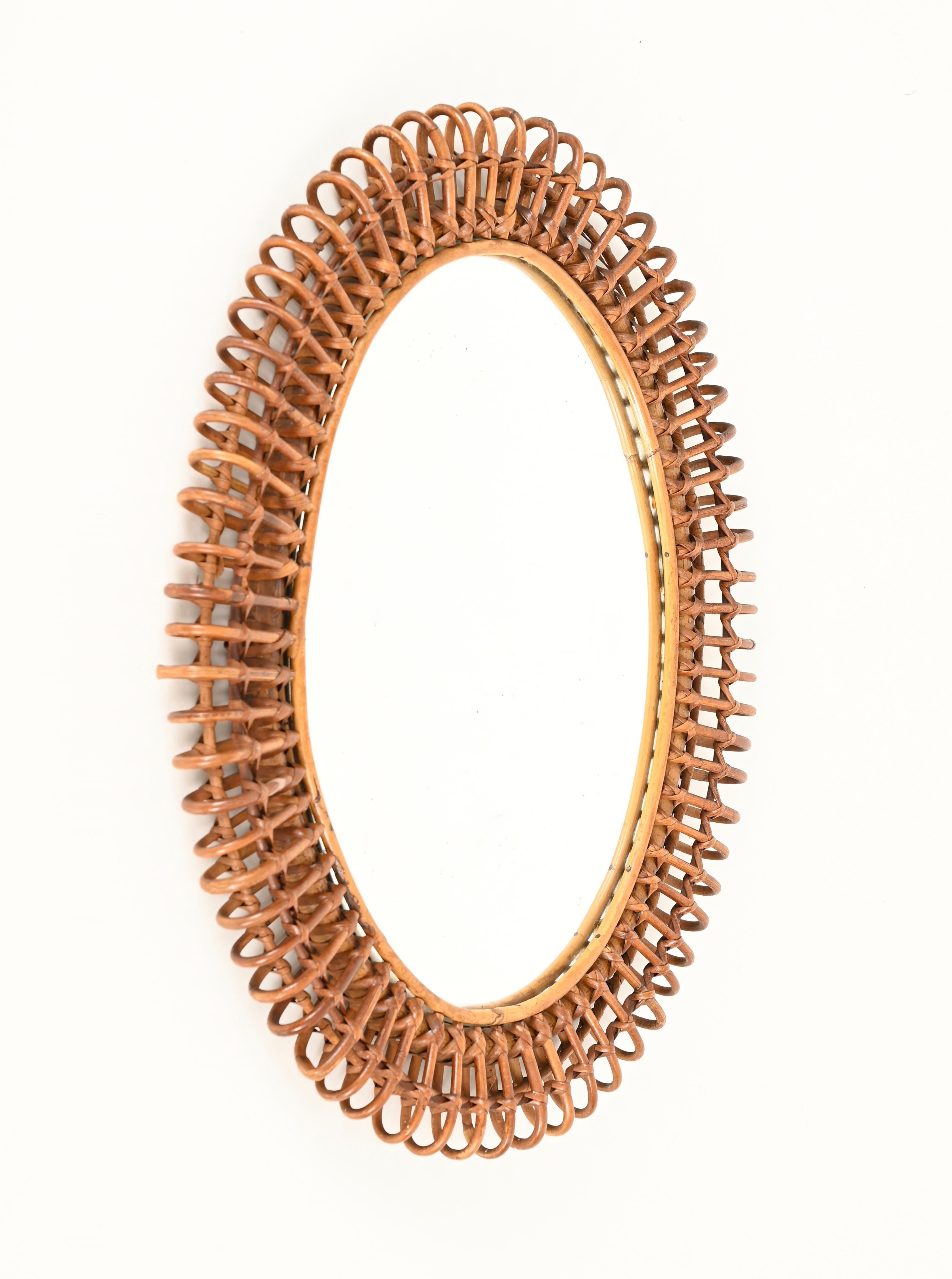 Magnifique miroir ovale de style Côte d'Azur en bambou, rotin courbé et osier tressé à la main. Ce charmant miroir organique a été conçu par la maîtrise de Franco Albini et fabriqué à la main en Italie dans les années 1960.

En fabuleux état et