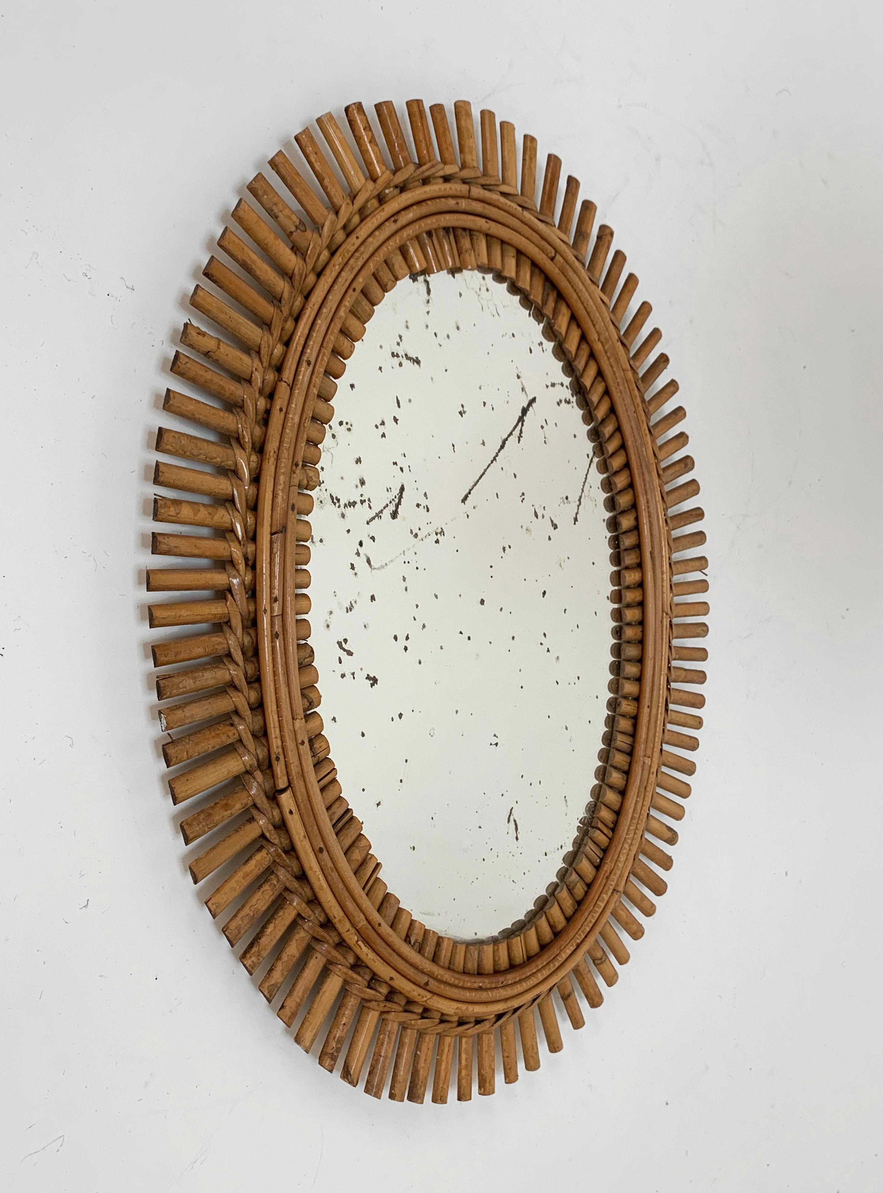 French Riviera oval wall mirror in bamboo and rattan, 1960s midcentury.
The mirror is original, has the signs of the time. We can also replace it with a new one without additional costs. 
Measures: Cm 55 x 42.