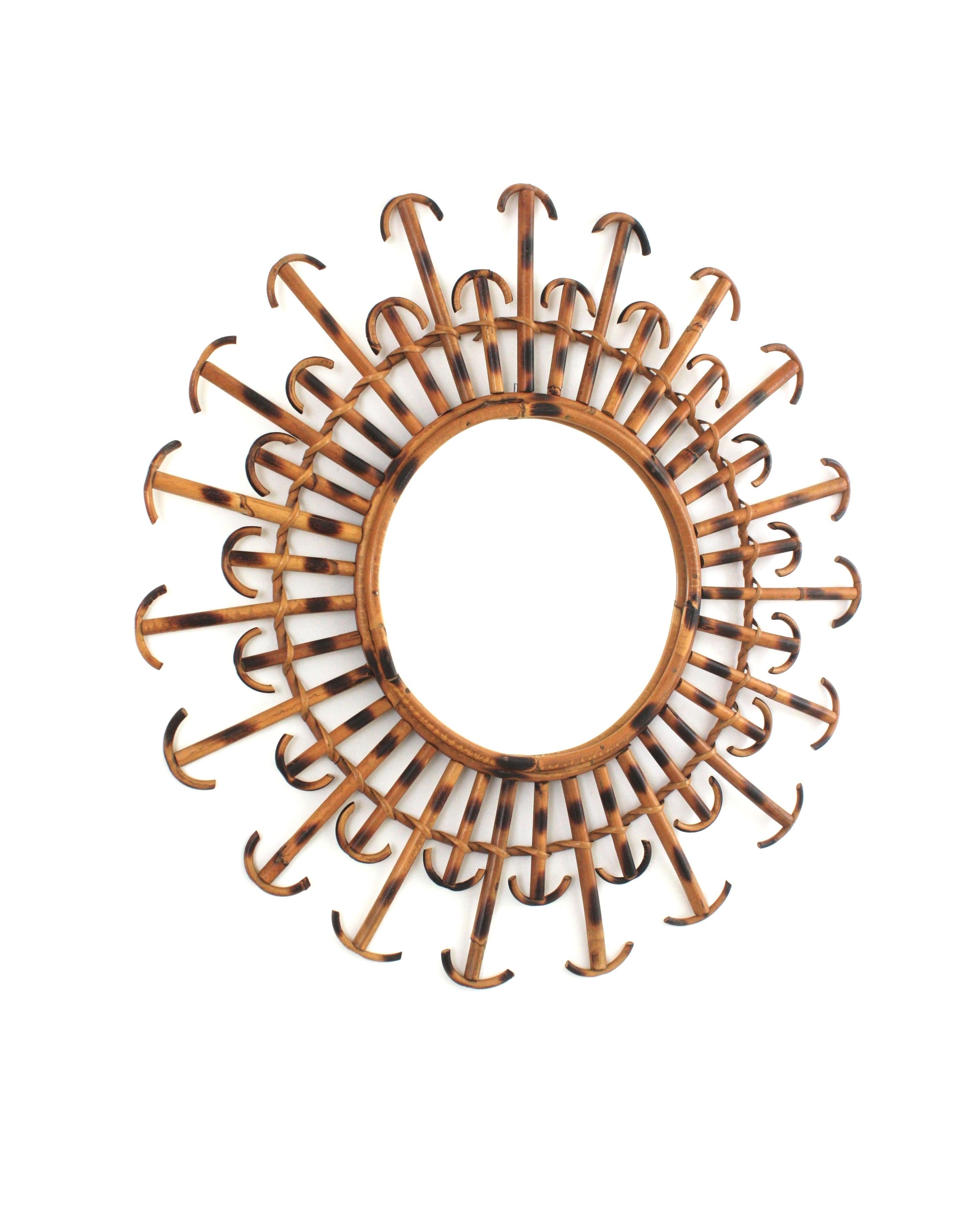 Auffälliger Spiegel mit Blumen- oder Sonnenschliff, handgefertigt aus Rattan und Weidengeflecht mit Pyrographie-Verzierungen und geschwungenen Abschlüssen. Frankreich, 1950er Jahre.
Dieser Spiegel hat zwei Schichten mit abwechselnden Strahlen in