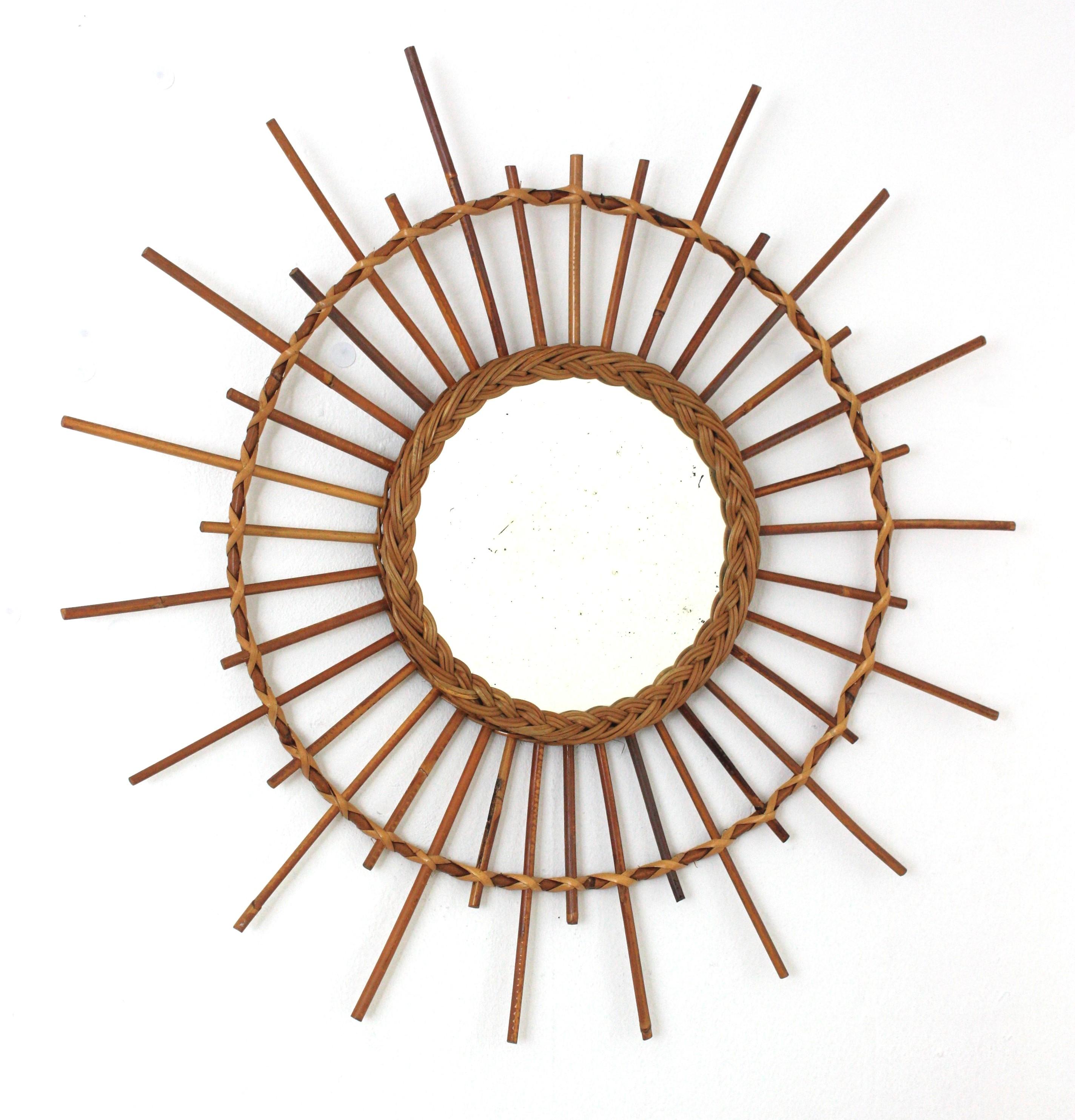 Coastal rattan and wicker sunburst / starburst mirror, France, 1960s.
Hand crafted starburst sunburst mirror with rattan rays and woven wicker ring surrounding the central glass. 
This mirror will add all the freshness of the Mediterranean French