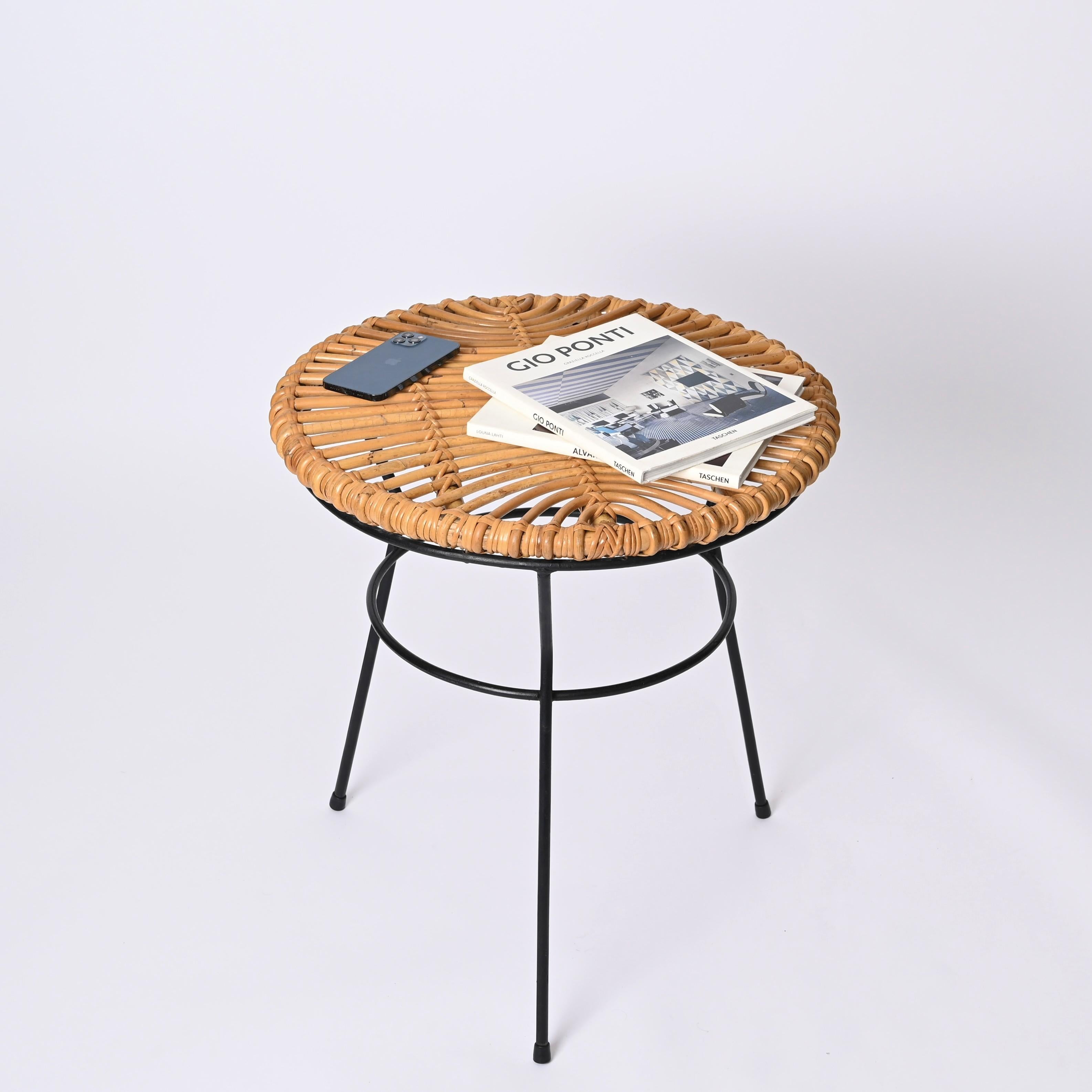 Fantastic round tripod coffee table in curved bamboo, rattan and woven wicker with black iron base. This lovely French Riviera style table was designed by Roberto Mango and produced in Italy during the 1960s.

This coffee table has a fantastic round