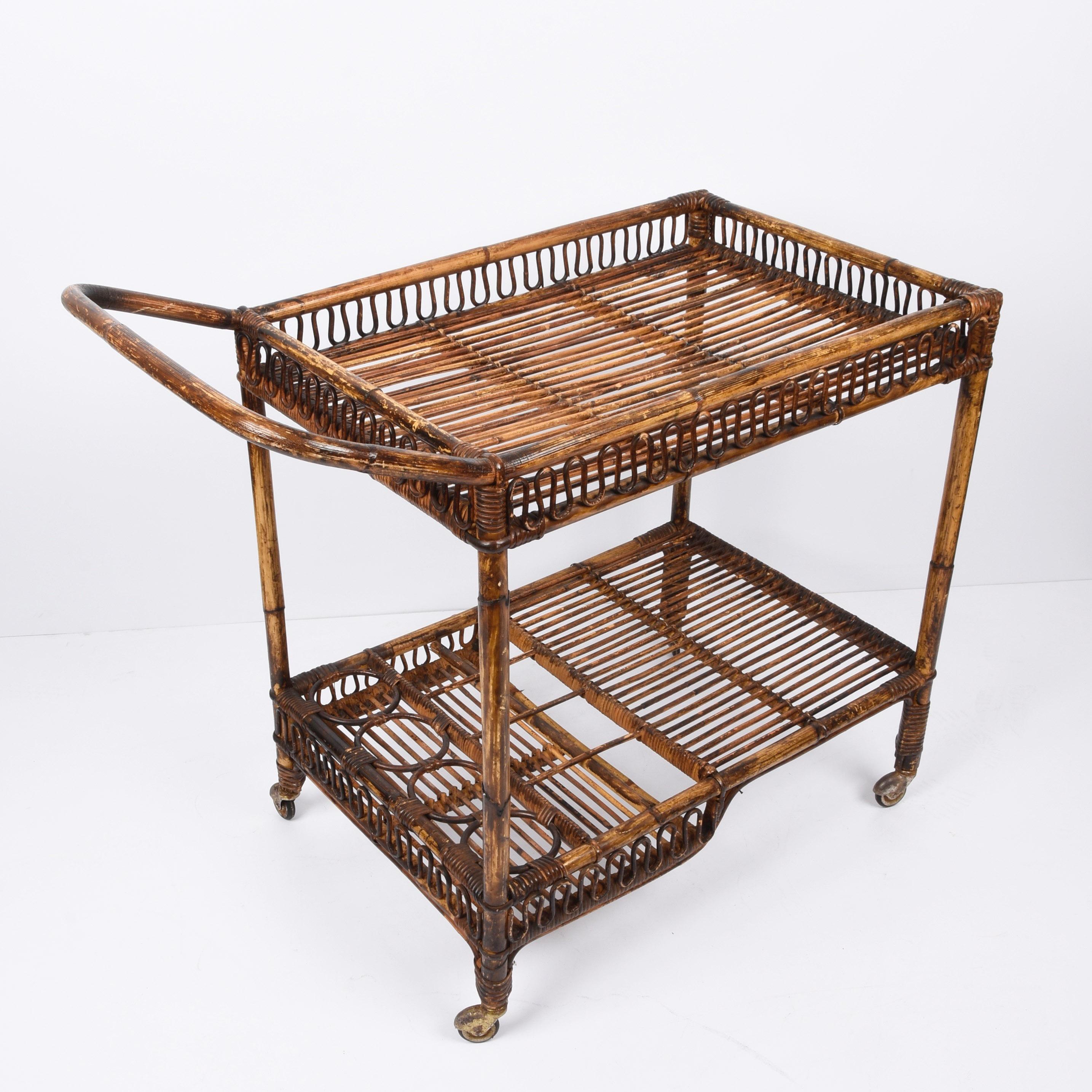 Fabulous midcentury French Riviera rectangular bamboo and rattan trolley bar cart. This amazing piece was designed and produced in France during the 1960s.

This piece is unique as it has the main structure in bamboo and the double level surfaces