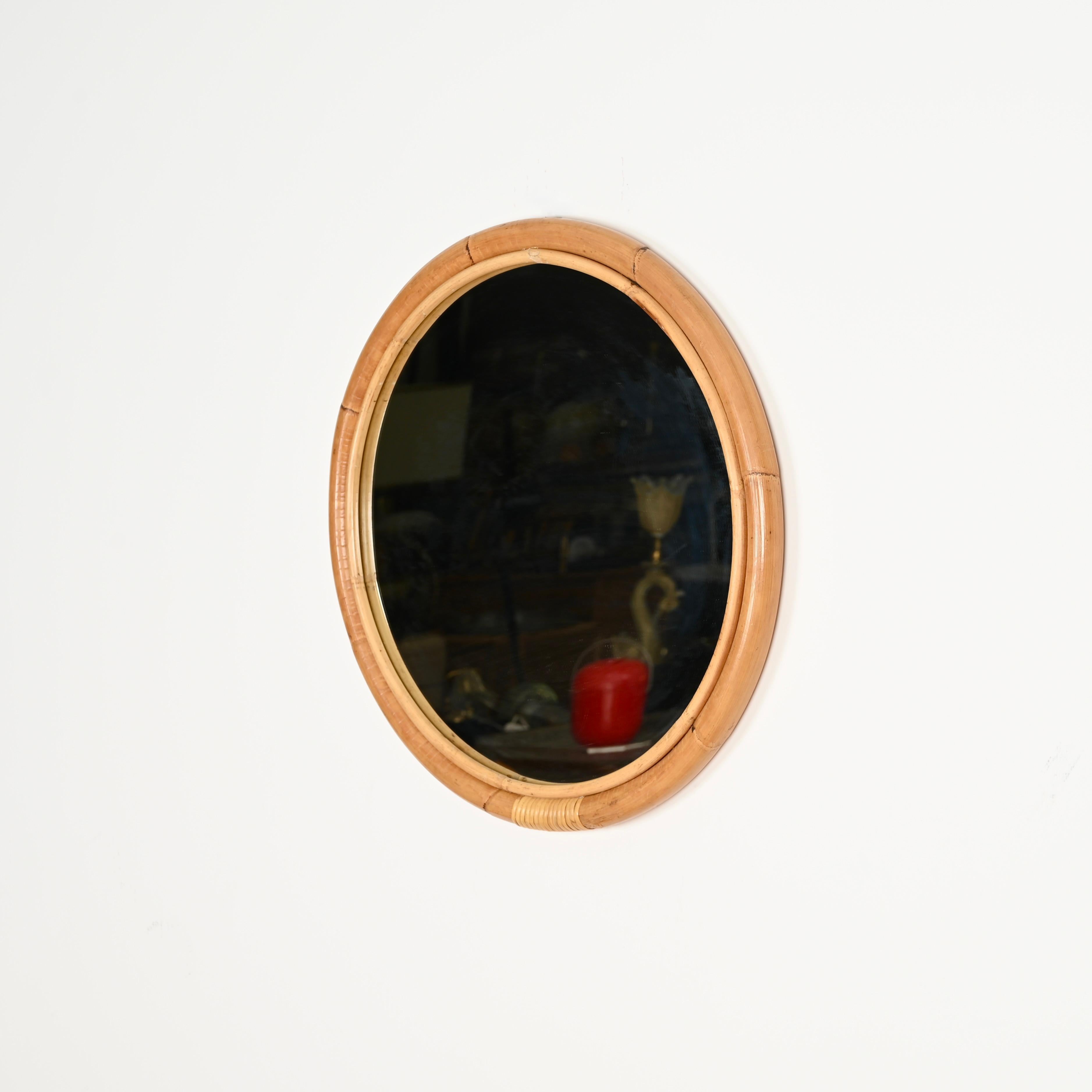Splendido specchio rotondo del Mid-Century con tripla cornice in canne di bambù ricurve e vimini intrecciato a mano. Questo delizioso specchio in stile Costa Azzurra è stato prodotto in Italia negli anni Sessanta. 

In condizioni favolose e con un