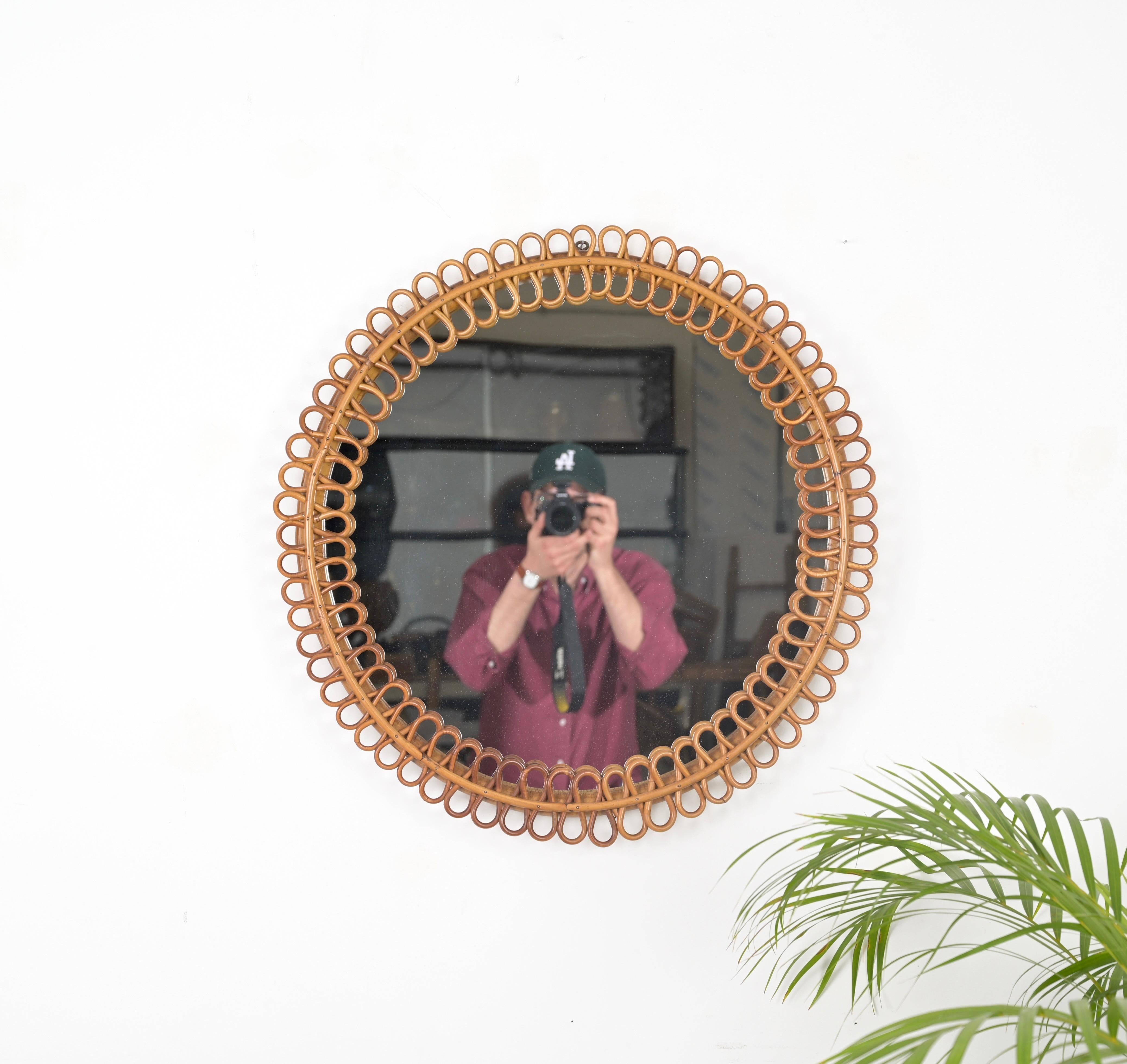 Remarquable miroir rond de style Côte d'Azur, entièrement réalisé en rotin et bambou courbé. Ce miroir spectaculaire et unique a été conçu par la maîtrise de Franco Albini et produit en Italie dans les années 1960. 

En parfait état et d'une
