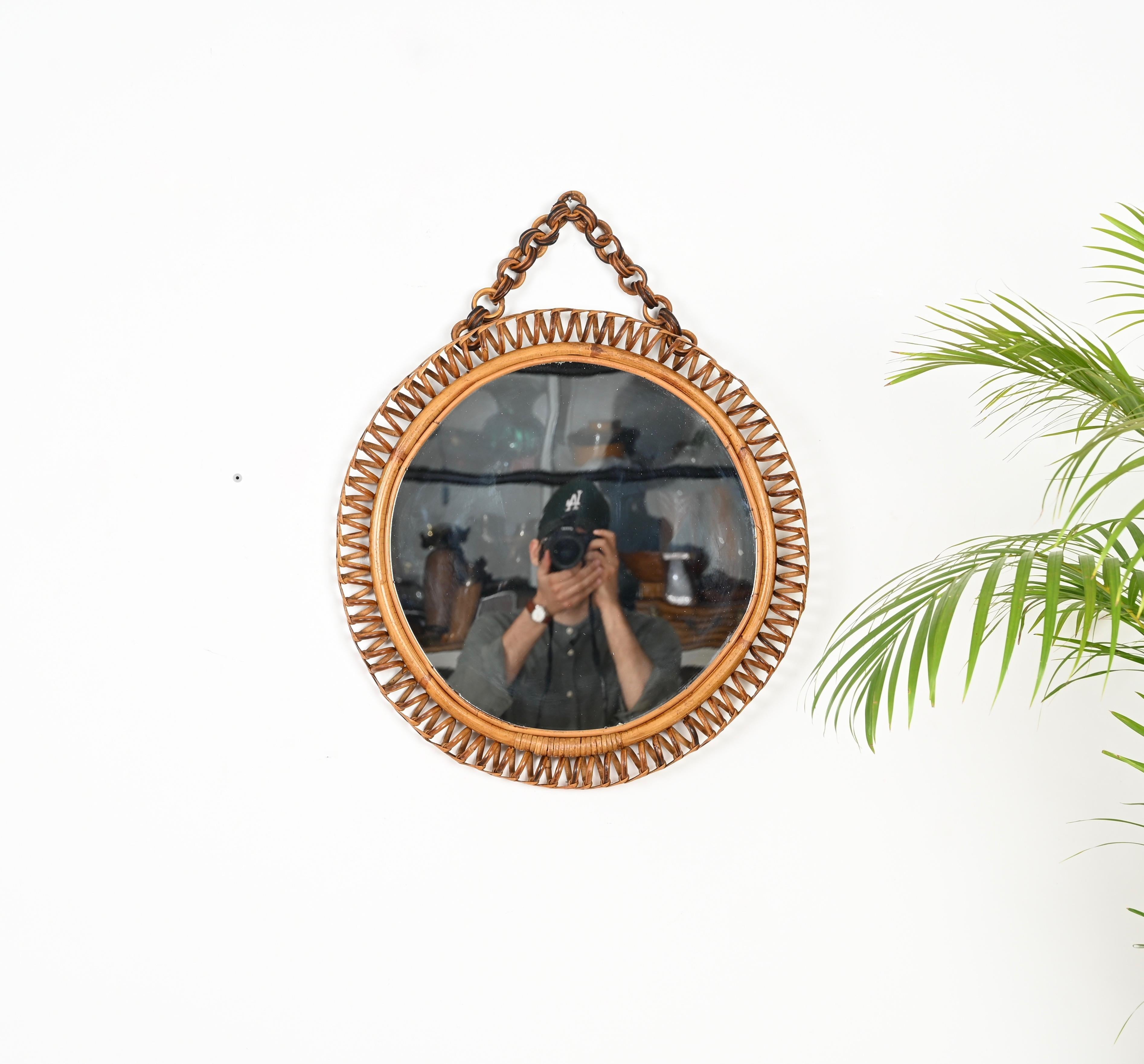 Stunning Mid-Century round mirror with chain fully made in curved rattan, hand-woven wicker and bamboo.  This unique French Riviera style mirror was designed in Italy during the 1960s.

The mirror is in amazing conditions and with a beautiful color.