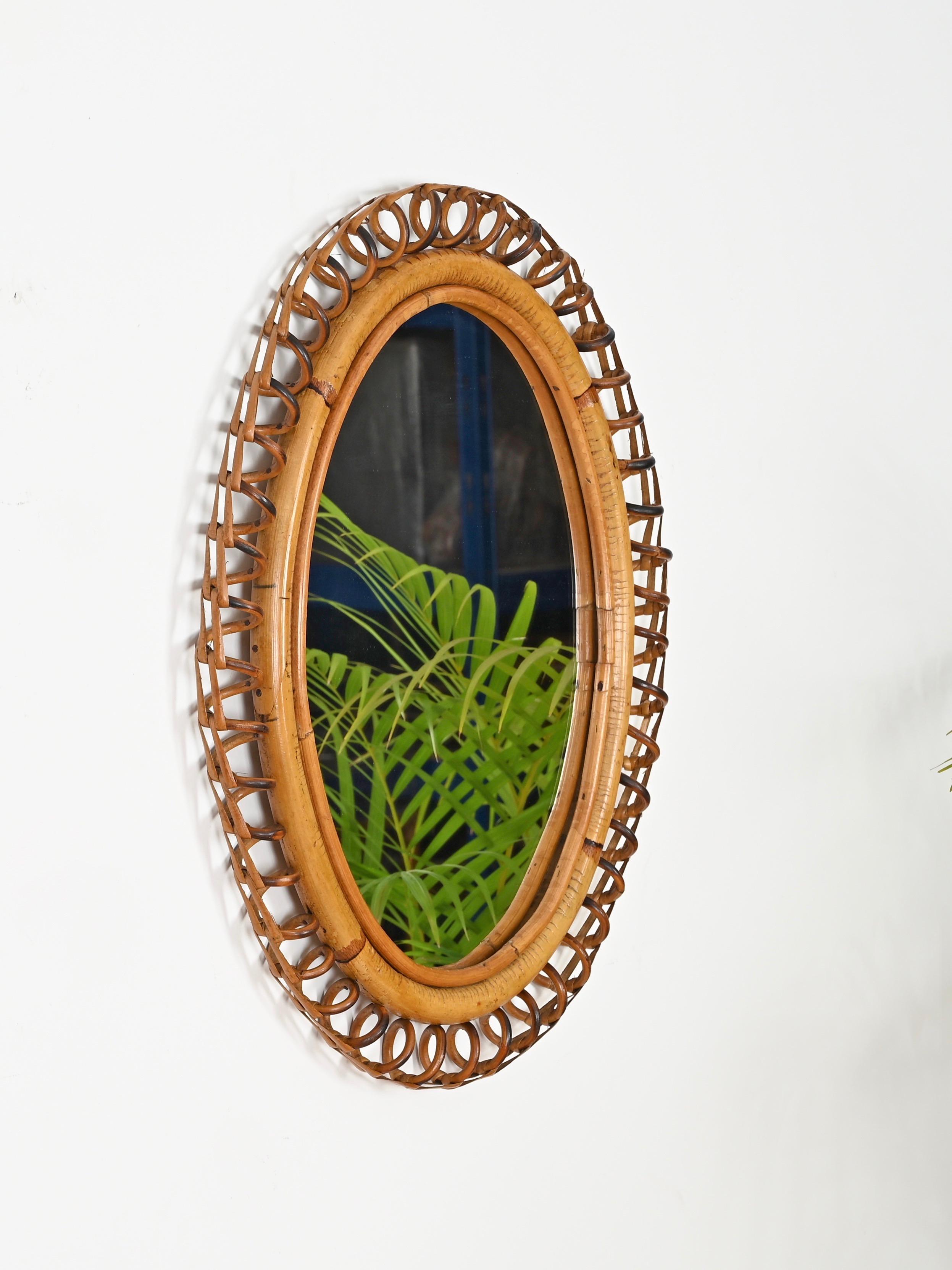 Splendido specchio in stile Costa Azzurra completamente realizzato in rattan curvato, bambù e vimini. Questo affascinante specchio del Mid-Century è stato realizzato in Italia negli anni '60 ed è in condizioni incredibili, con un bellissimo colore