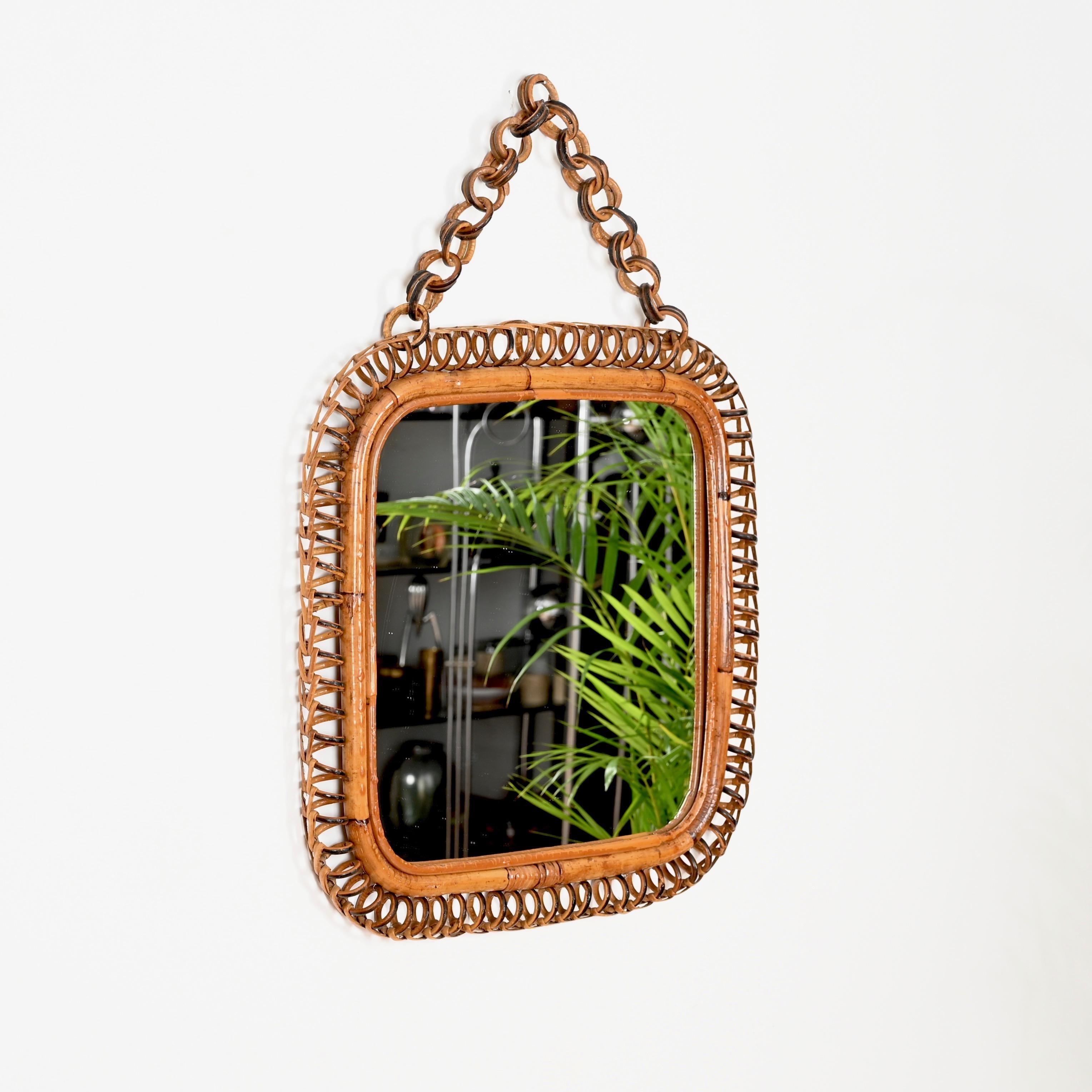Meraviglioso specchio del Mid-Century di forma quadrata con catena completamente realizzato in rattan curvo, vimini intrecciato a mano e bambù.  Questo specchio unico in stile Costa Azzurra è stato progettato in Italia negli anni Sessanta.

Lo