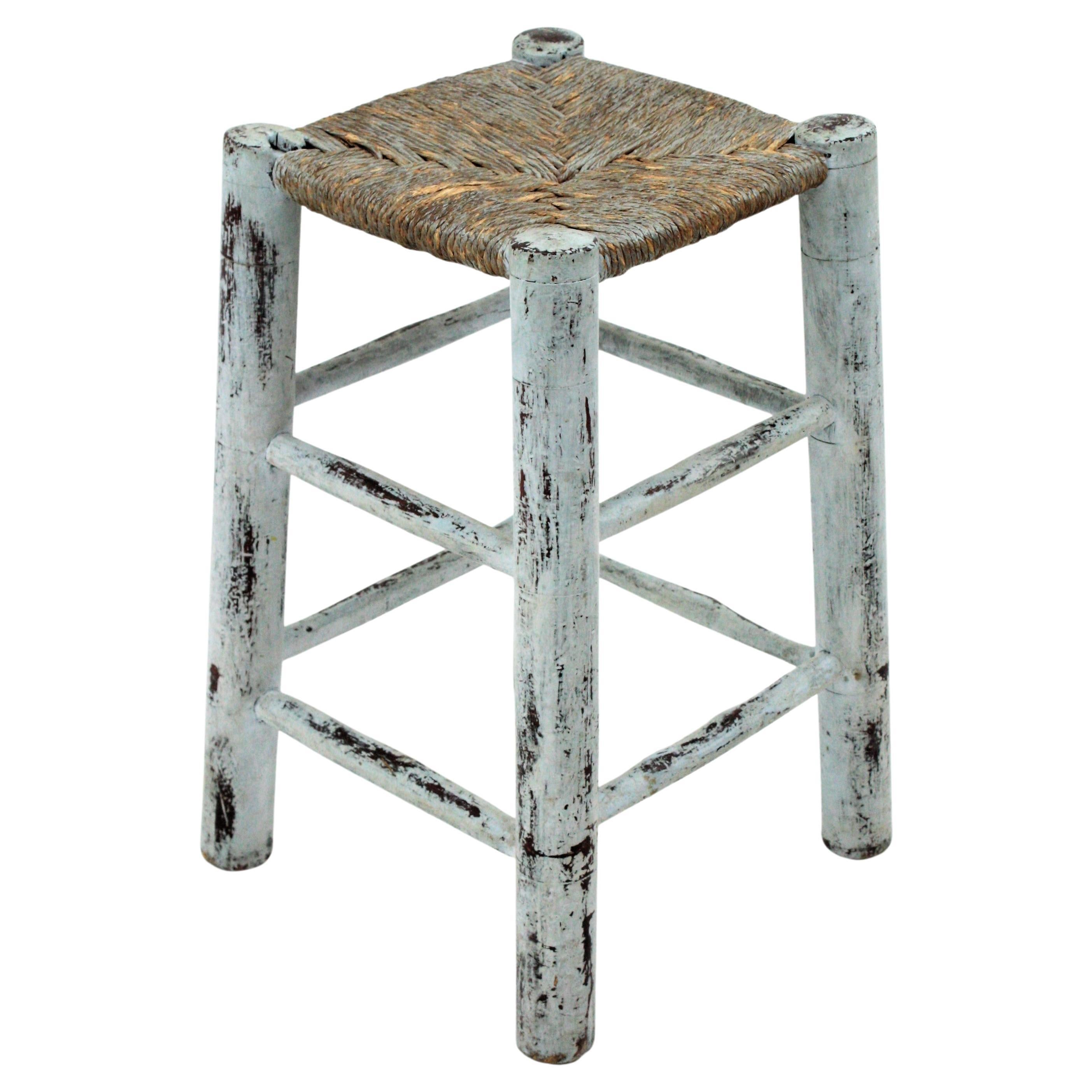 Coastal Wooden stool with rope seat and blue patina finish. France, 1940s-1950s.
This rustic stool has a wooden structure with turned legs and an aged patina in soft blue. The seat is made with hand braided rope grass rope that has been carefully