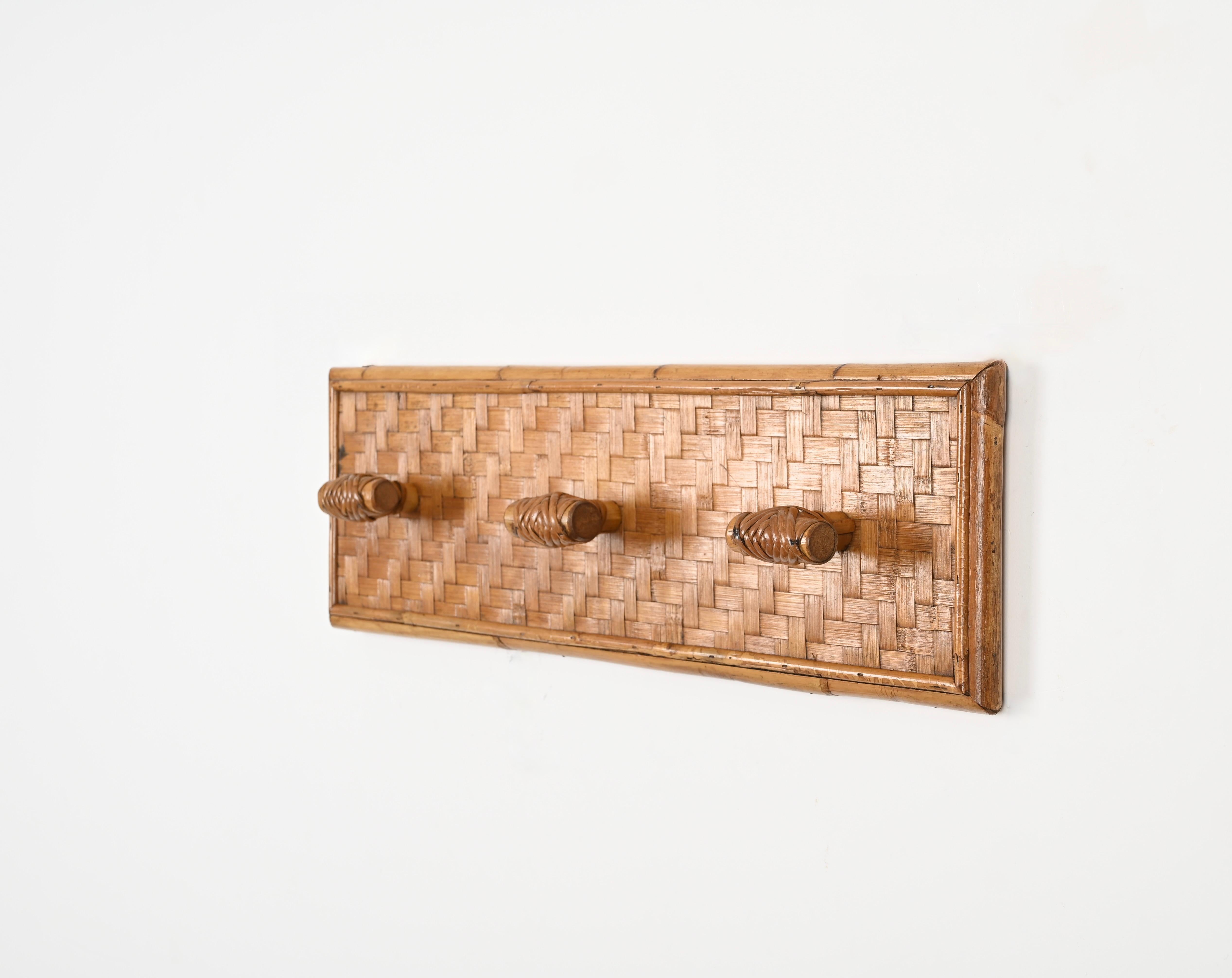 Stunning Mid-Century coat rack in woven rattan, wicker and bamboo. This gorgeous piece was hand-crafted in Italy during the 1960s. 

This French Riviera style coat rack features 3 lovely hooks decorated in  hand-woven wicker, the rectangular