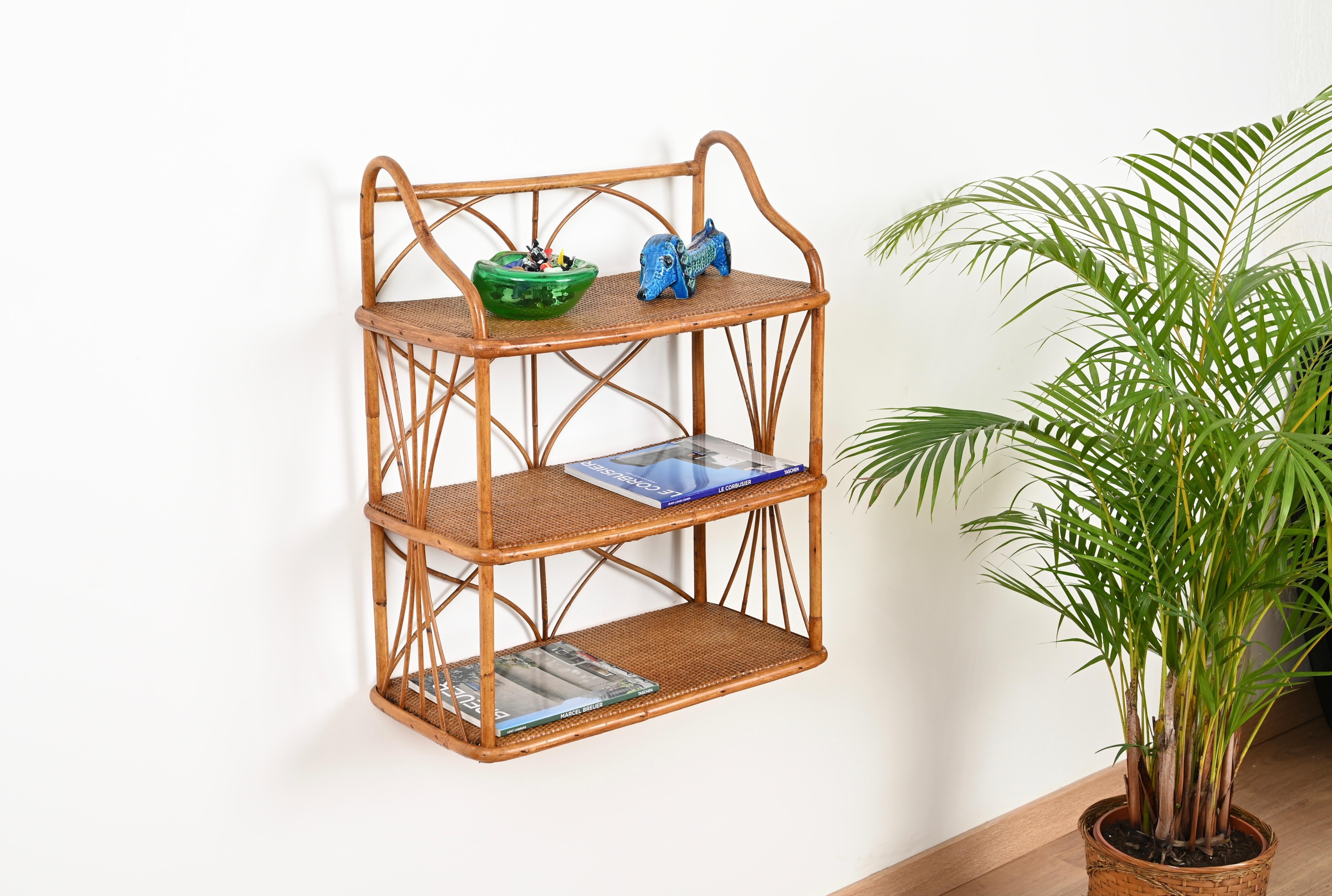 Stunning Mid-Century wall shelf in curved bamboo, rattan and hand-woven thin wicker. This unique French Riviera style wall shelf was hand-made with perfect proportions in Italy during the 1960 and it's stylish design is attributed to the mastery of