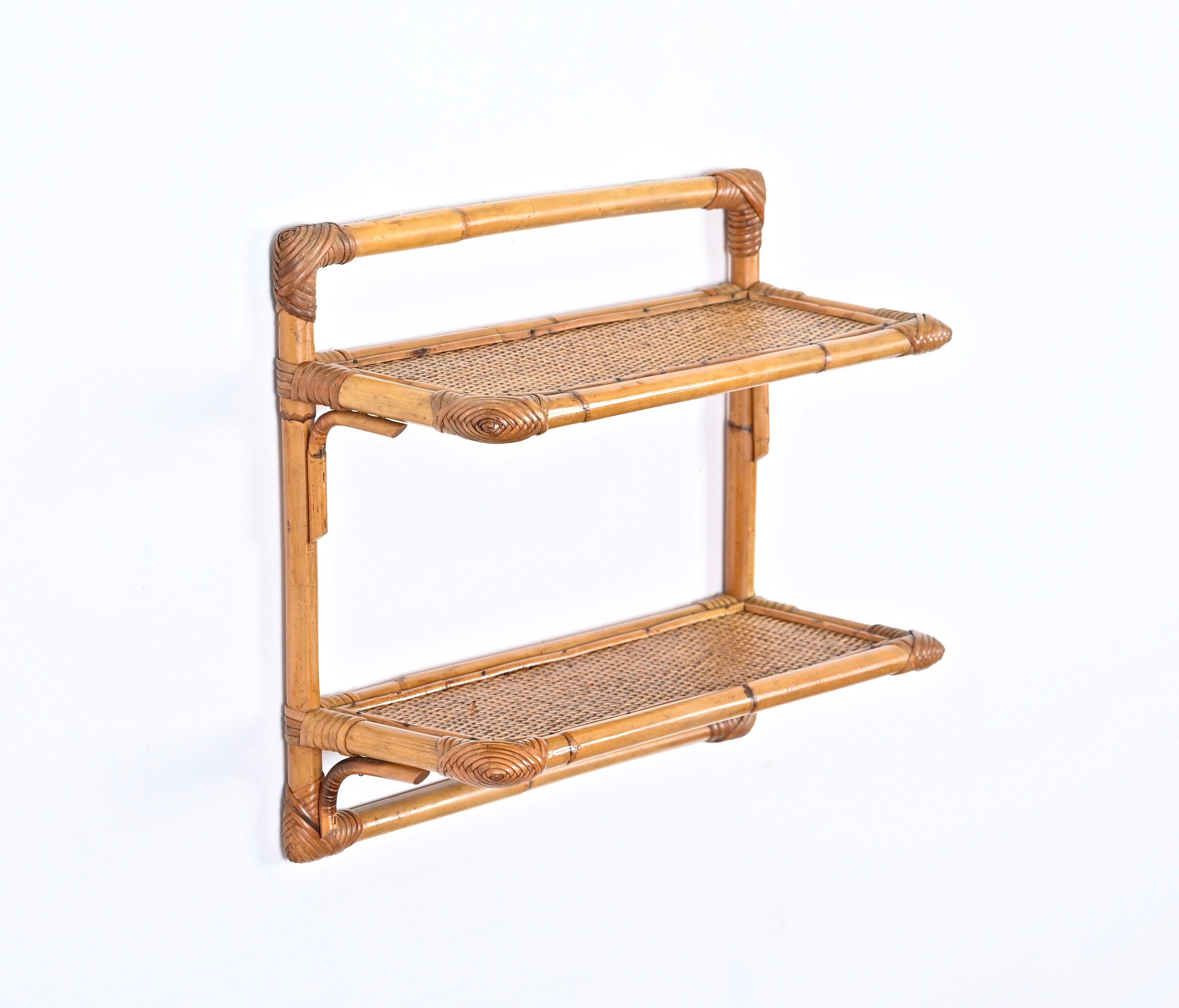 Lovely Mid-Century two tier wall shelf in bamboo and rattan. Vivai del Sud likely designed this beautiful piece in Italy in the 1970s.

This structure is made in bamboo canes with the rectangular shelves made in wood and finished with woven wicker.
