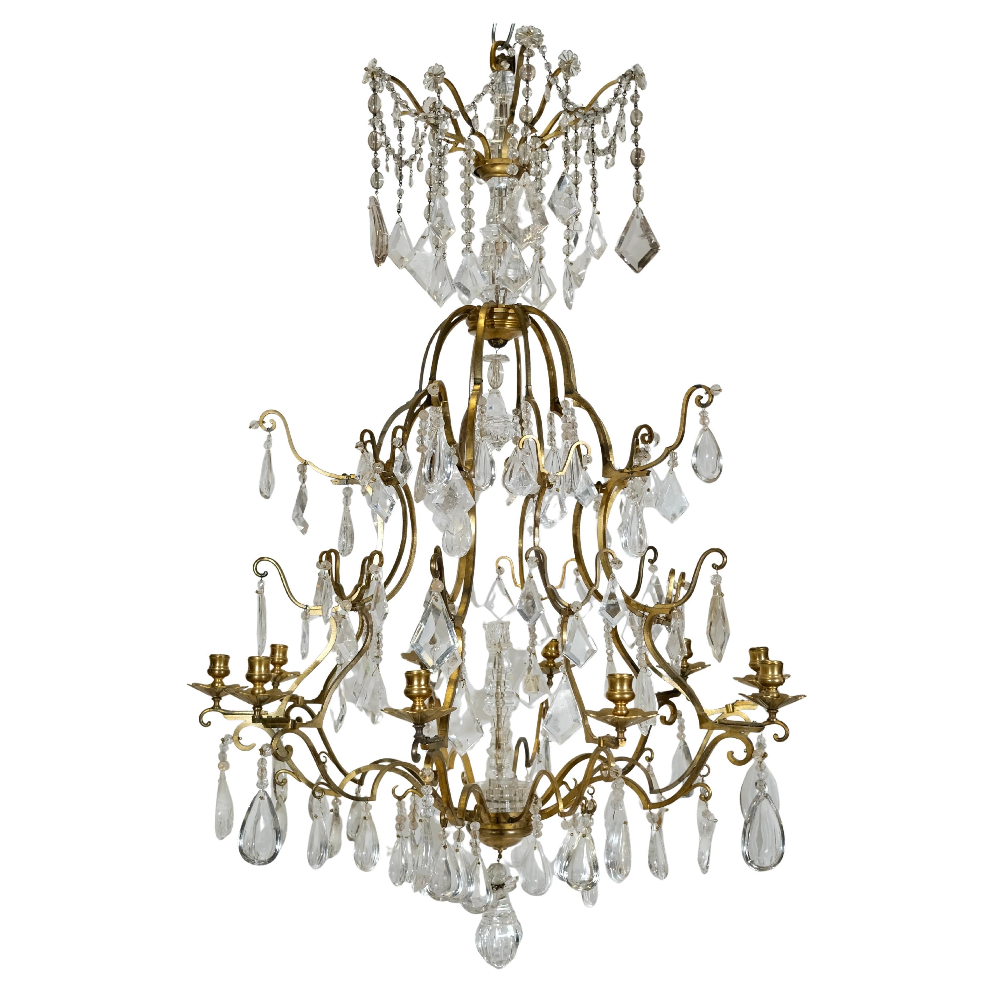 Questo raffinato lampadario del XIX secolo è un eccezionale esempio di raffinato artigianato, caratterizzato da una struttura in bronzo dorato riccamente patinato che è invecchiata con grazia nel tempo. I toni caldi e profondi del bronzo dorato