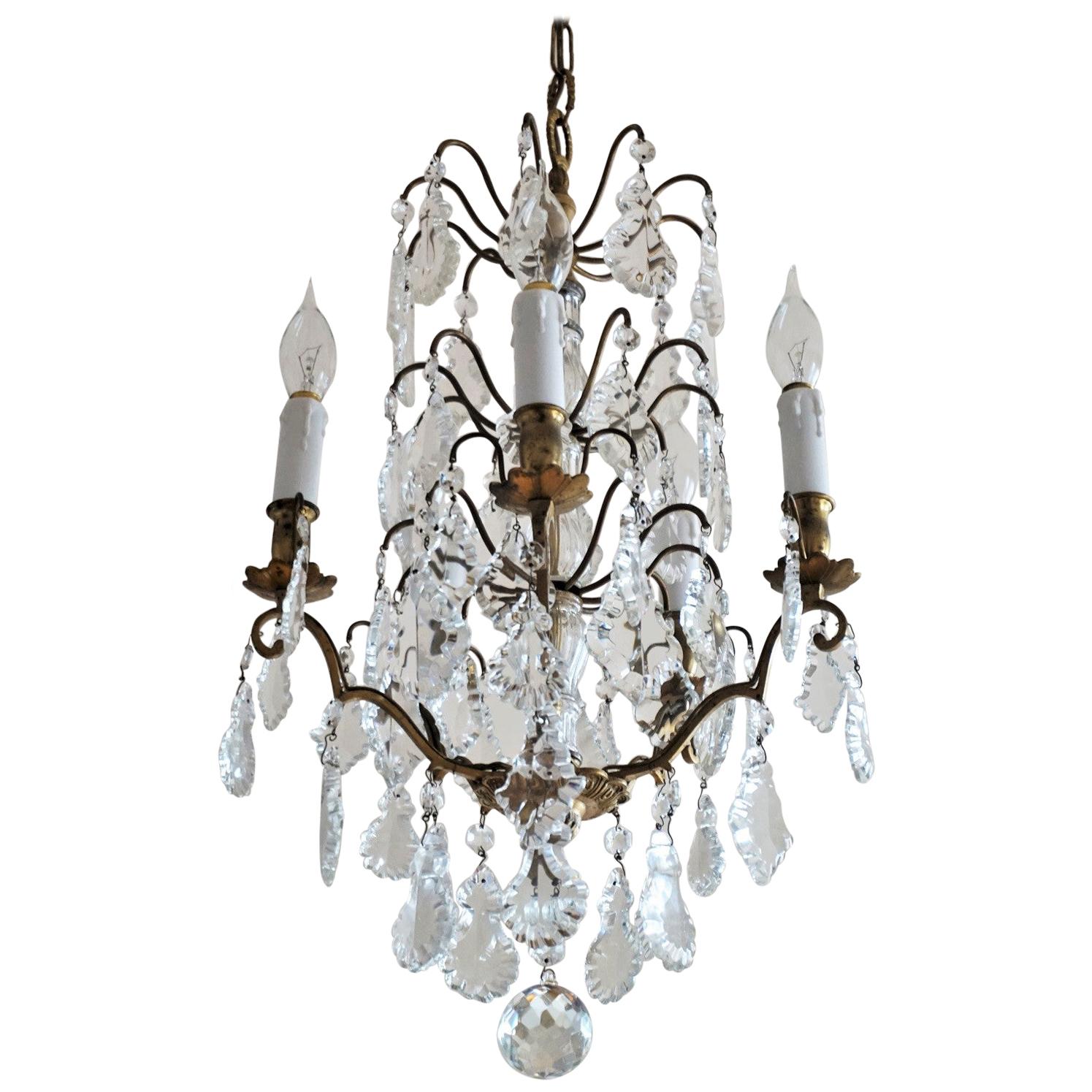 A lovely antique Baccarat crystal electrified chandelier, gilt brass beautifully decorated with several tiers of large pendaloques in different shapes and sizes, finishing at the bottom with a large clear cut crystal ball, includiing chain and