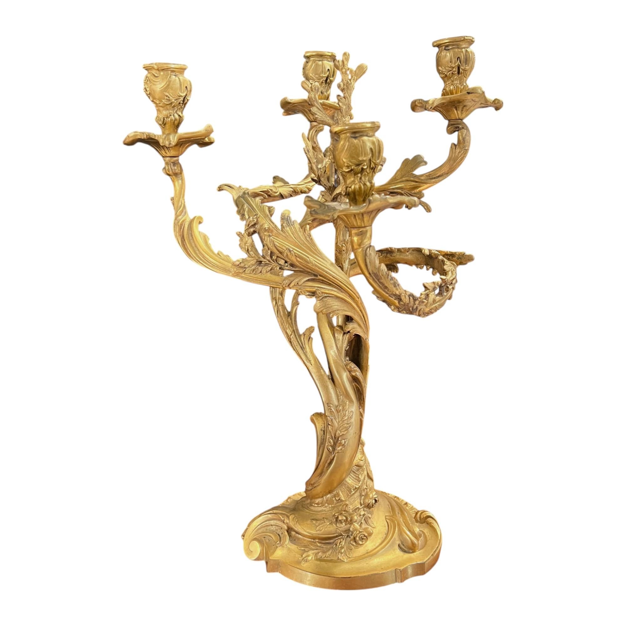Dieses Paar französischer Kandelaber aus vergoldeter Bronze ist im Rokokostil gegossen und zeichnet sich durch blattförmige Arme, Akanthusblätter und asymmetrische Schnörkel aus. Die reiche Vergoldung unterstreicht die Eleganz des 18. Jahrhunderts