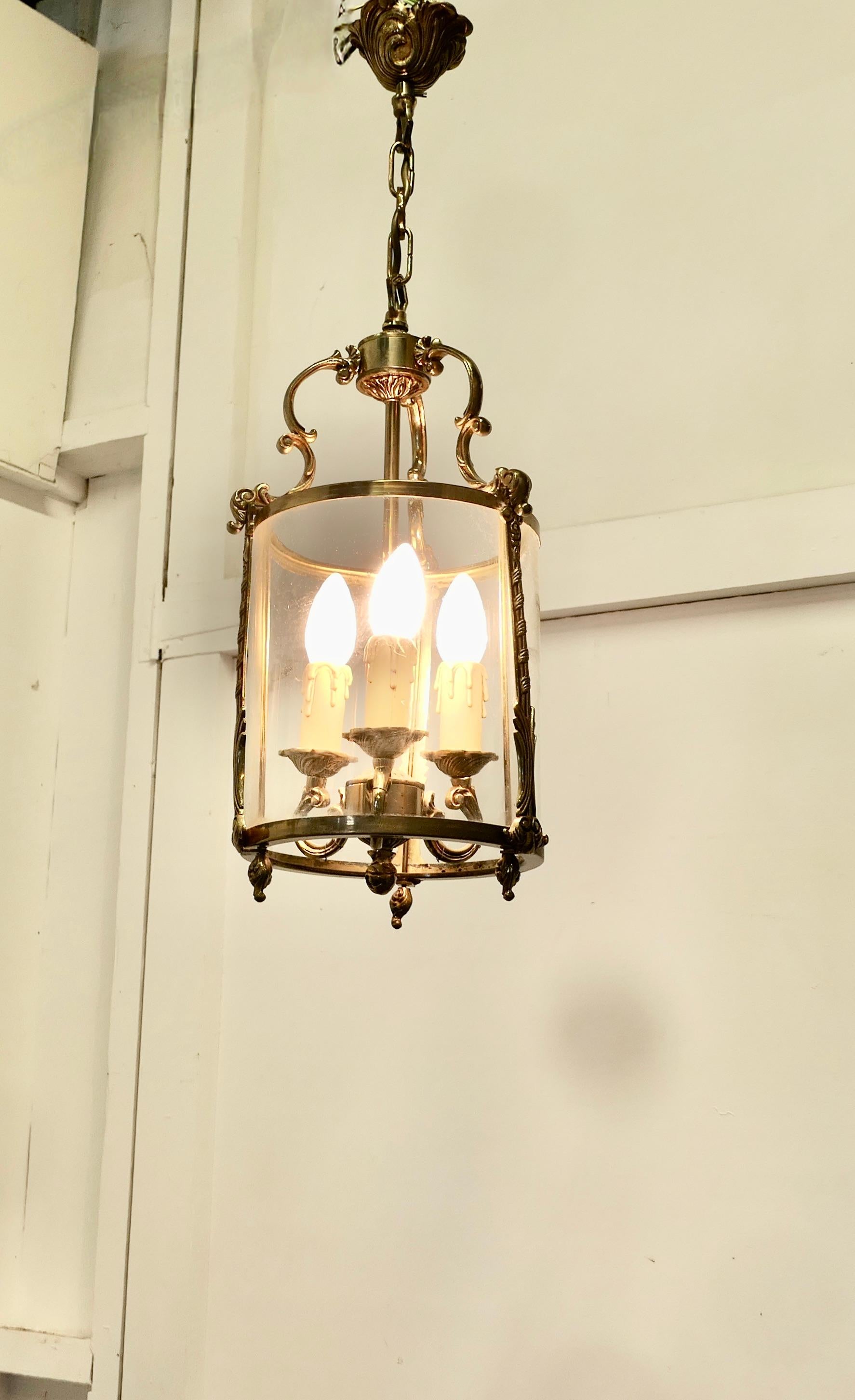  Lanterna da sala rococò francese in ottone e vetro A. Hall

Una lanterna in ottone di qualità superba, di forma circolare e decorata in stile francese con volute e foglie, appesa a un rosone decorativo in ottone.
La lanterna è dotata di 3 appliques