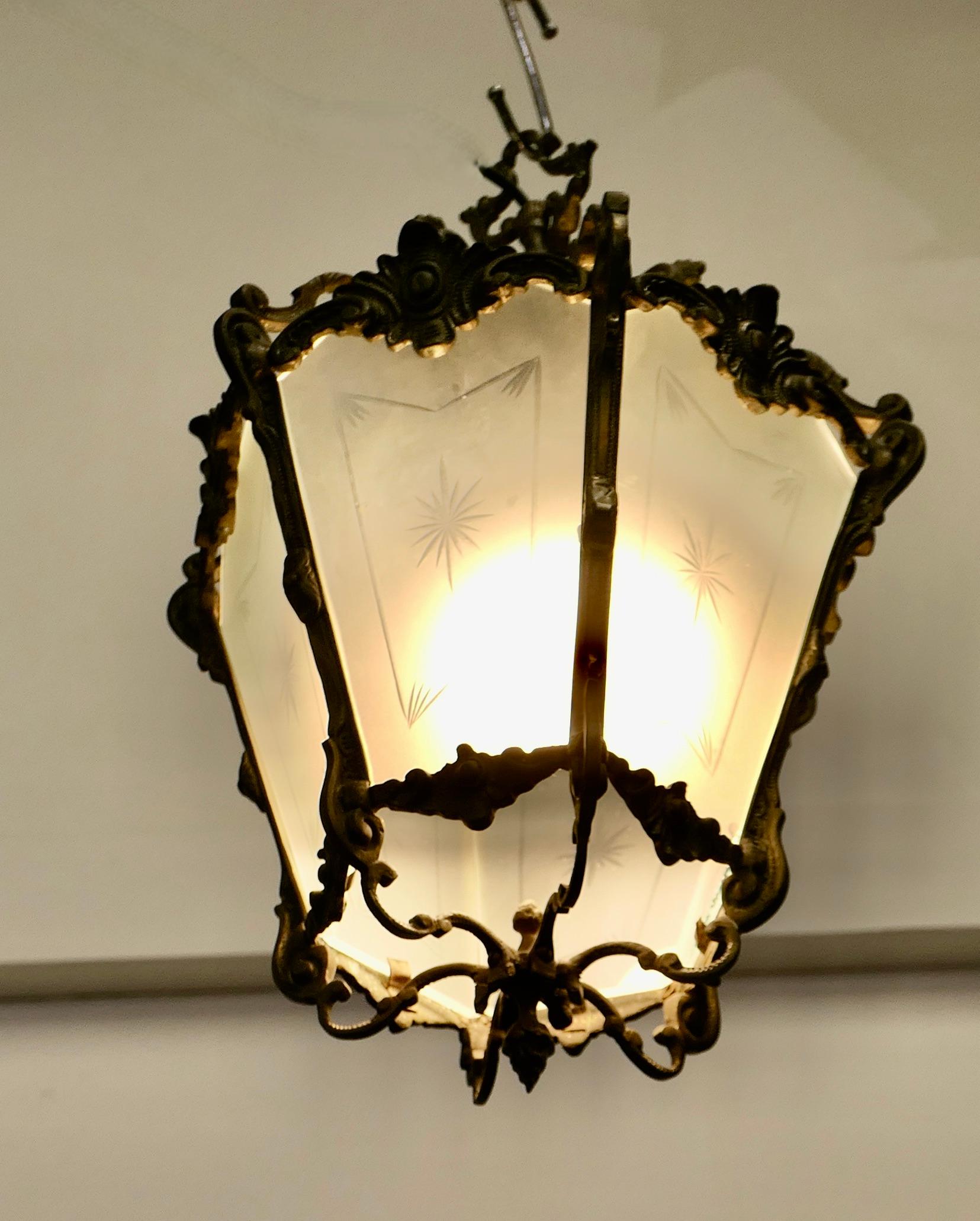  French Rococo Brass & Etched Glass Lantern Hall Light

A superb quality heavy brass lantern, the light is decorated in the French style with leaves, the lantern has 6 sides and the glass panels are decorated with starbursts
The lamp is in good