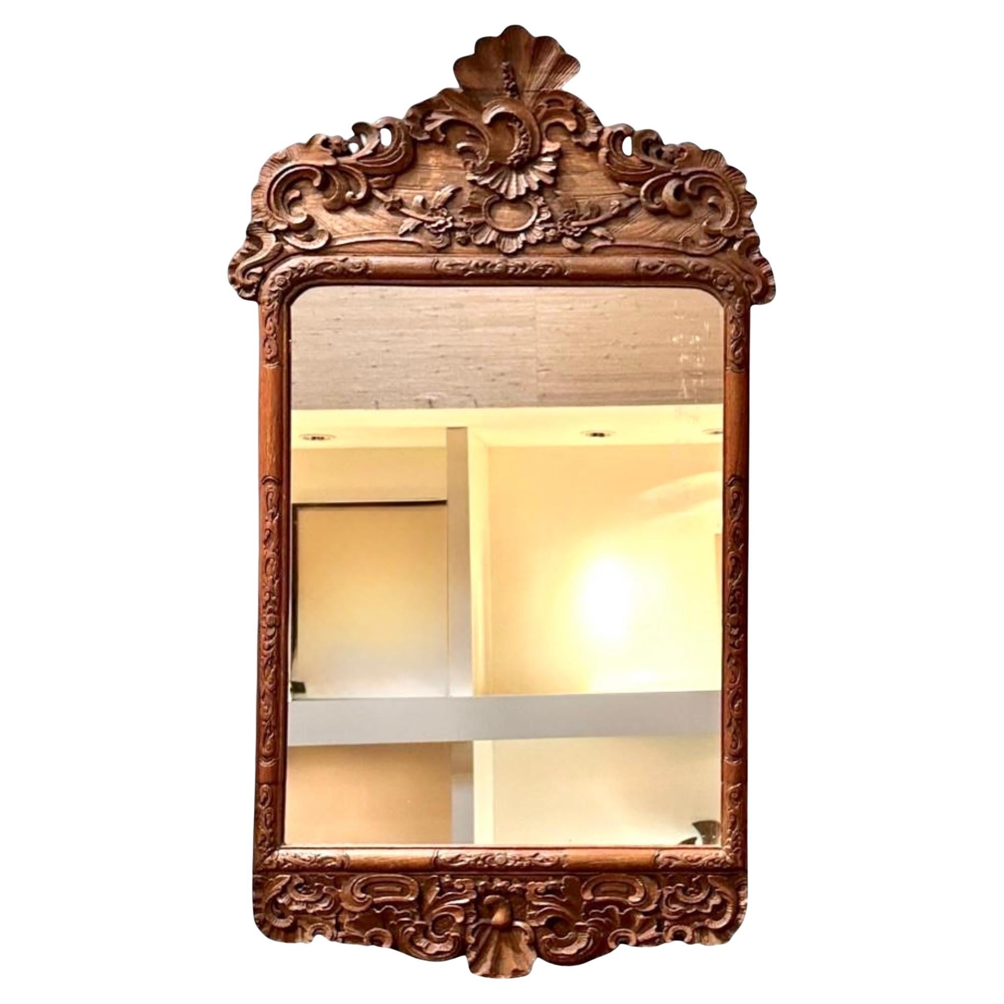 Specchio francese del XVIII secolo in Oak intagliato. Lo specchio è caratterizzato da un fogliame a scorrimento profondamente intagliato, foglie d'acanto e motivi floreali, che culminano in una drammatica cresta asimmetrica centrata da un audace