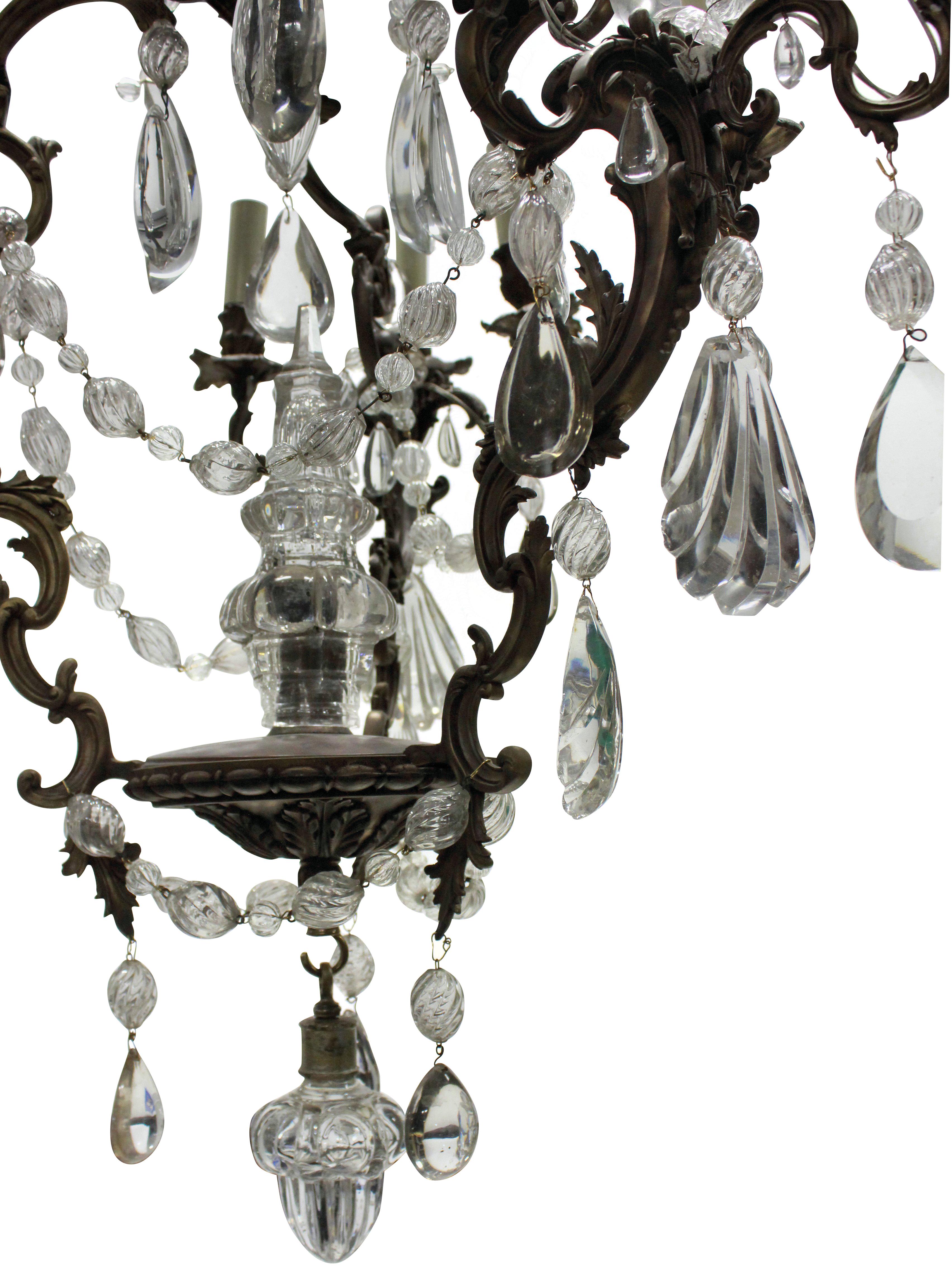A French Rococo bronze chandelier hung throughout with interesting cut and blown glass drops and swags with a central spire.