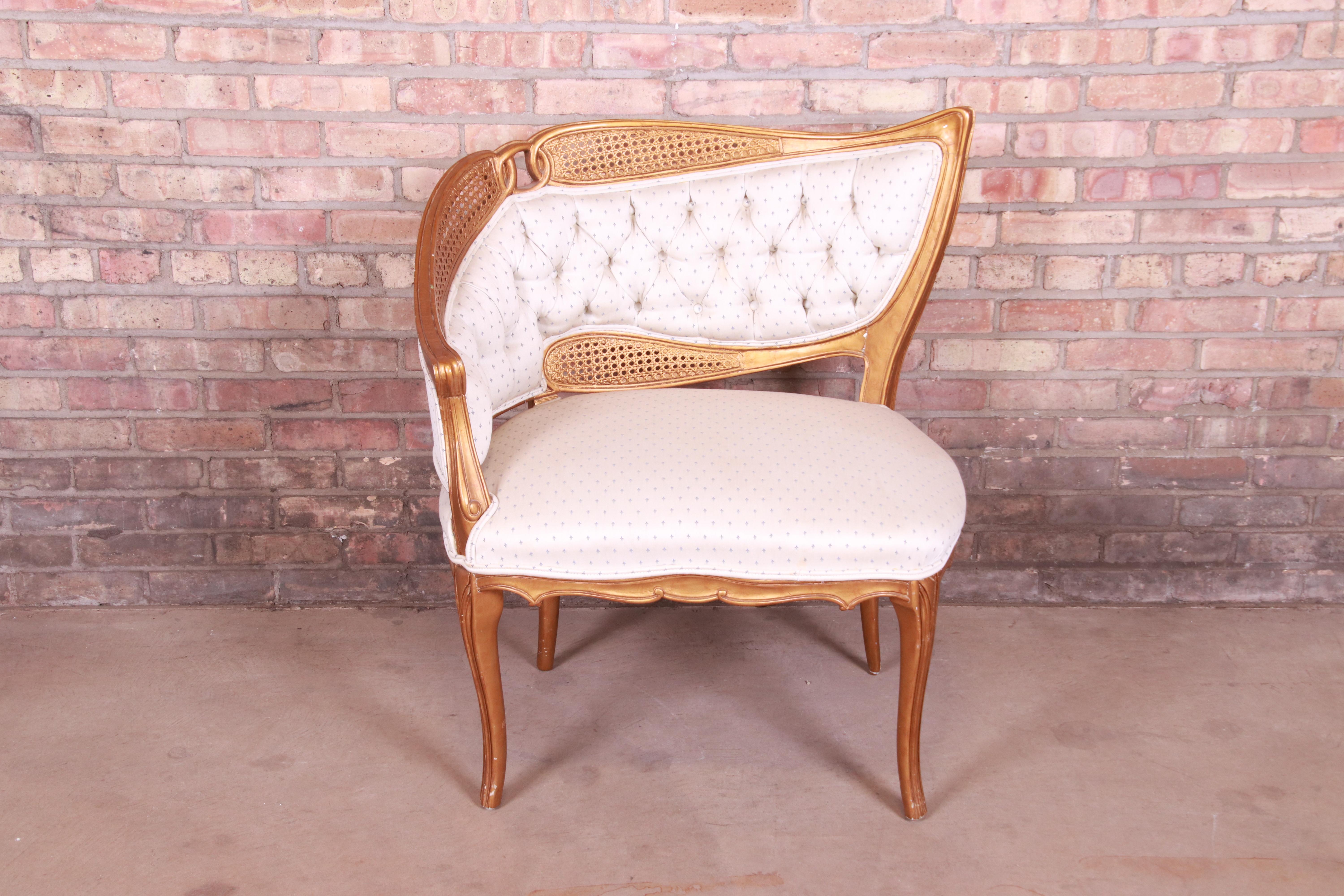 A gorgeous French Rococo Louis XV style gilded fireside club chair or lounge chair

Attributed to Grosfeld House,

Mid-20th century

Giltwood and caning, with upholstered seat and back.

Measures: 31