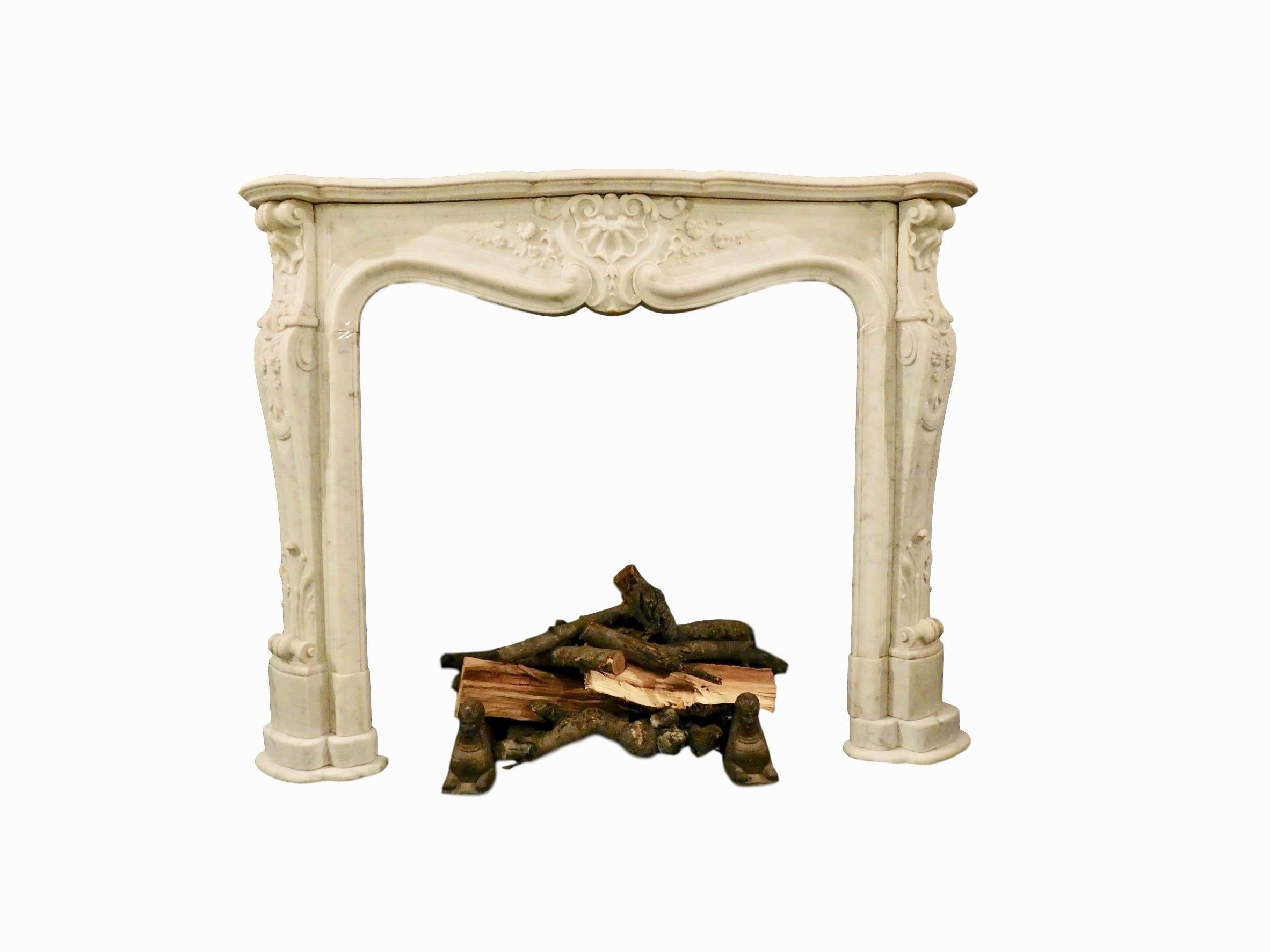 An important French Louis XV Carrara marble fireplace mantel. Serpentine top surface shelf, supported with intricately carved jambs ending in an acanthus leaf headed scrolled foot, the upper portion of jamb with floral and foliage decoration