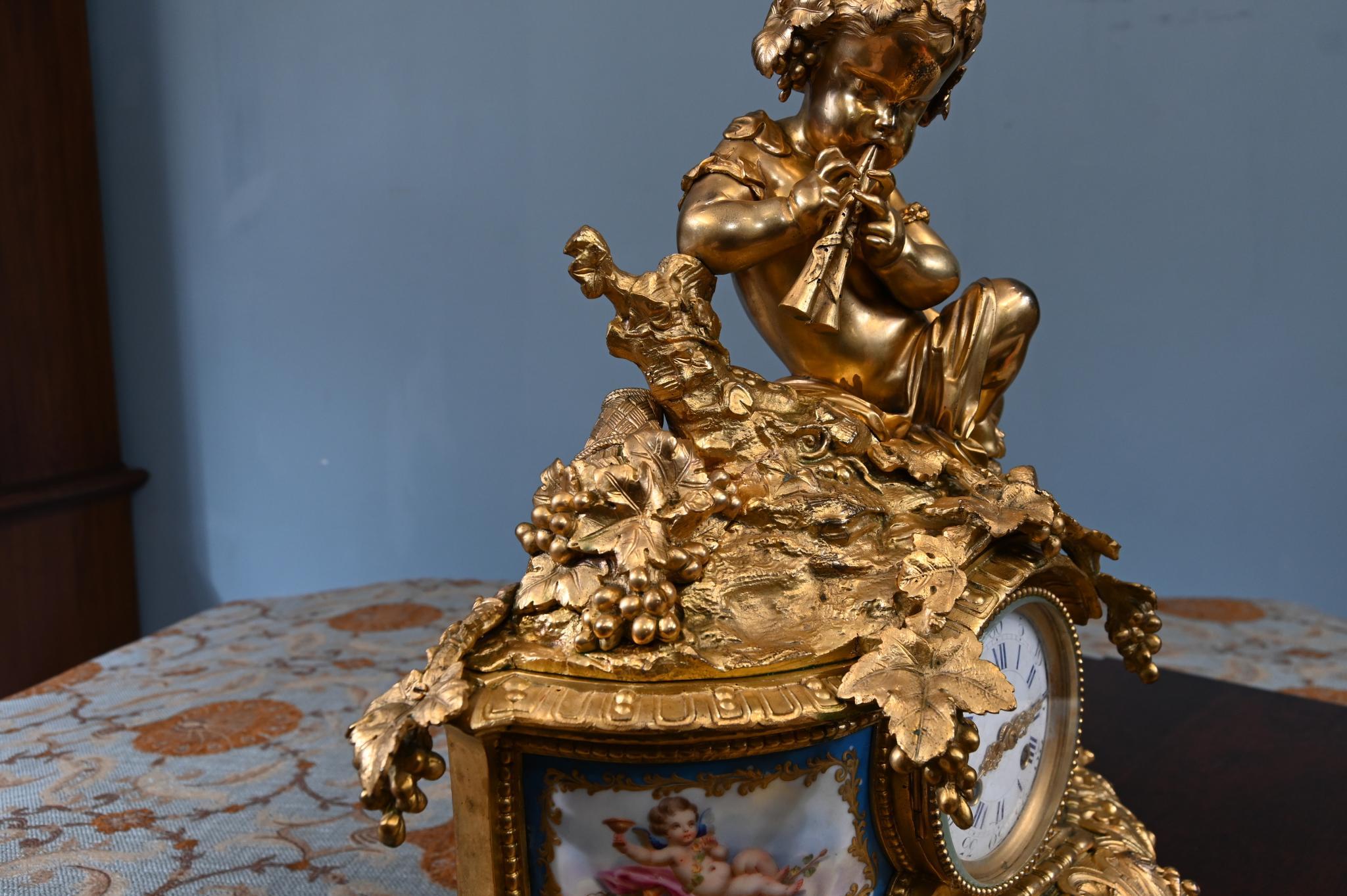 Very eye catching antique French mantel clock in the rococo style
Strong Rococo influence -flowing curves, scrolling foliage, and abundant
decorative detail
A beautifully modelled cherub/putto seated on top, playing a flute – a
playful, romantic