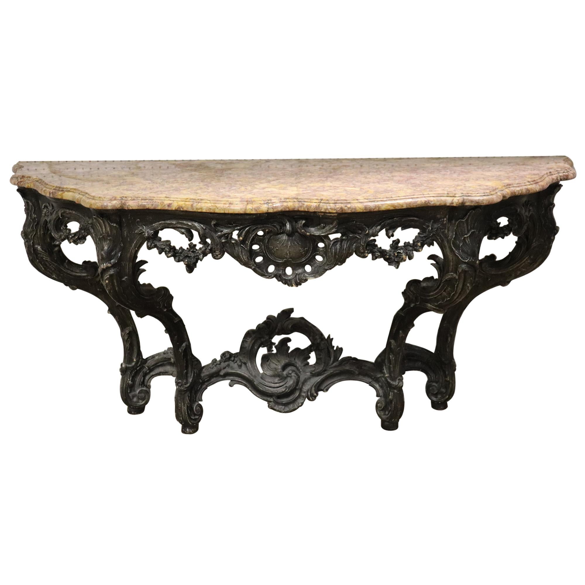 This is a beautiful and uniquely finish wall mounted console table. The table has a great slab of marble on top and a very unique dark almost ebonized or brown finish. The console measures 71 wide x 25 deep x 35 inches tall. Dates to the 1890s. Does