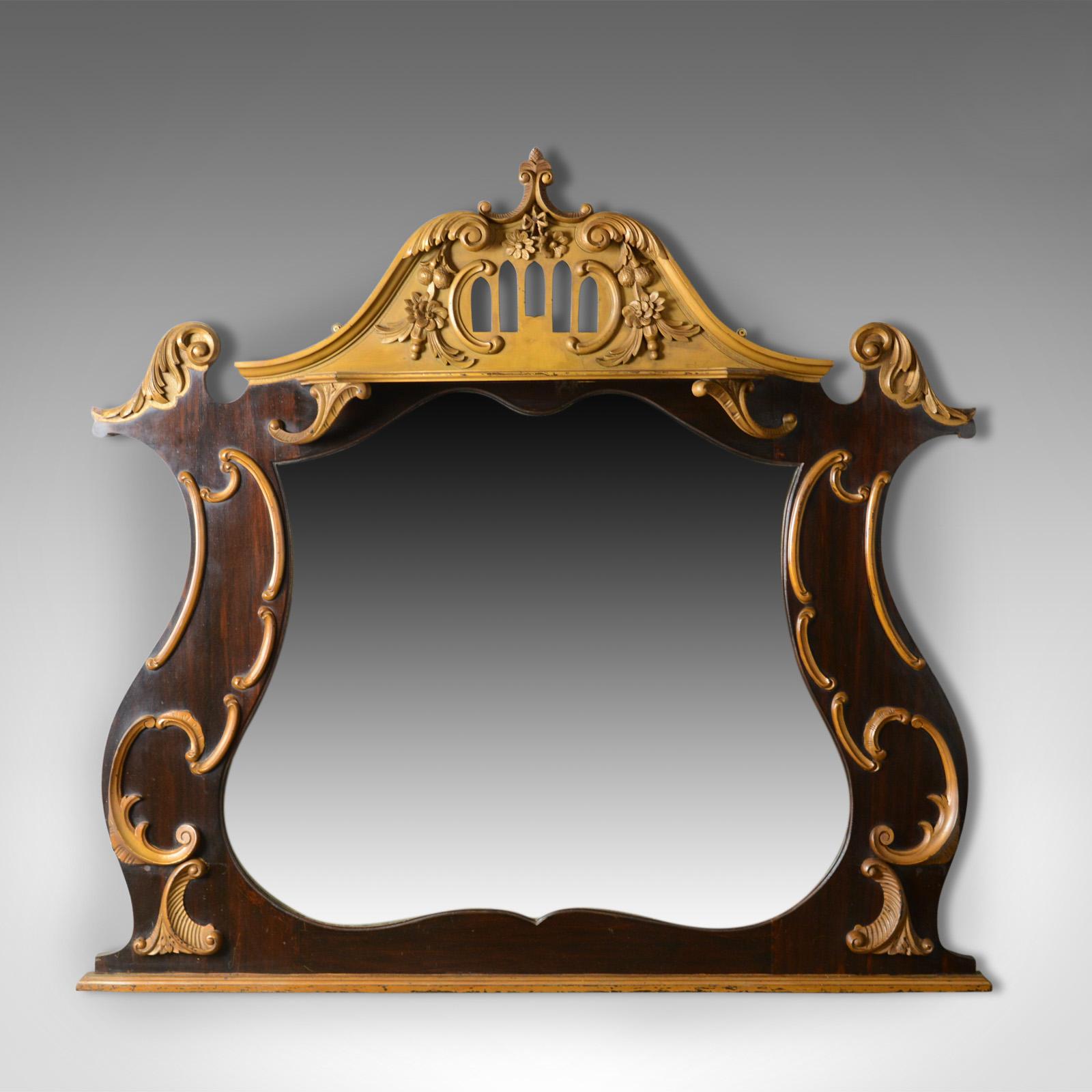 This is a large, French, Rococo revival wall mirror, a hall or overmantel mirror, ebonised with giltwood adornment dating to the early 20th century, circa 1910.

Attractive ebonised lyre shaped frame with gold appliqué
Pierced detail to the