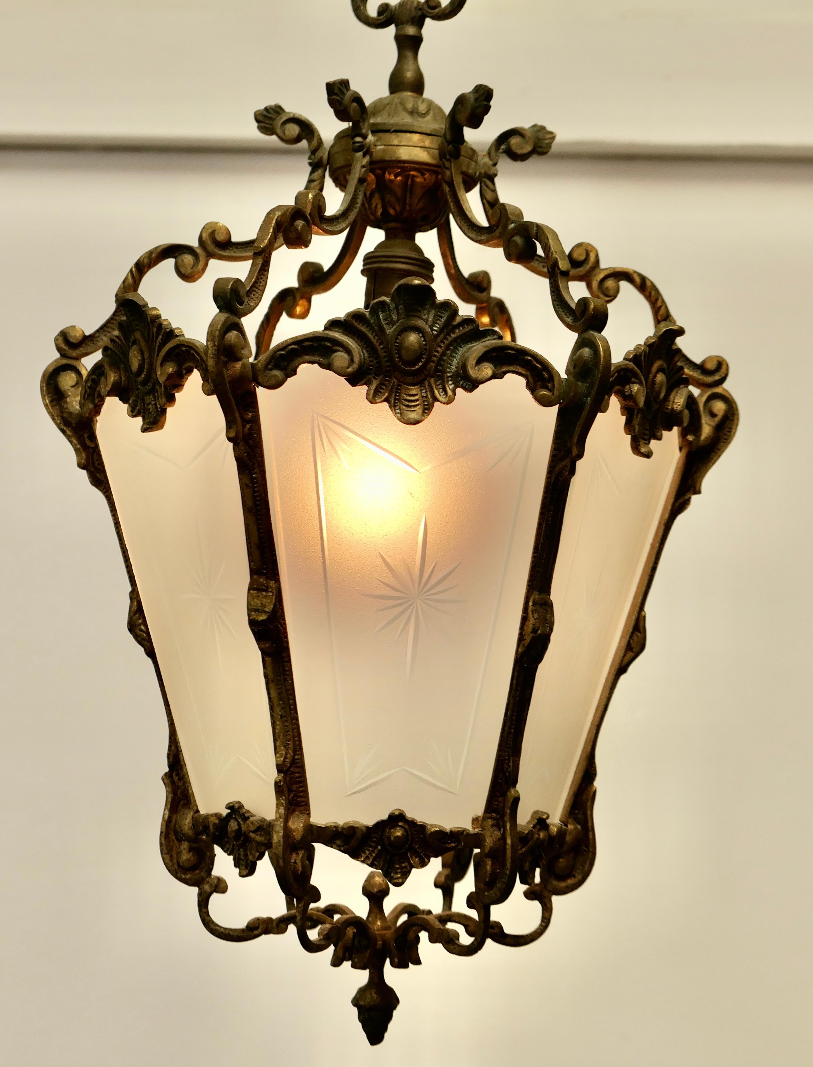 French Rococo Style Brass and Etched Glass Lantern Hall Light

A superb quality heavy brass lantern, the light has 6 opaque glass panels, these are etched with a starburst 

The lantern is decorated in the French style and it hangs from a brass