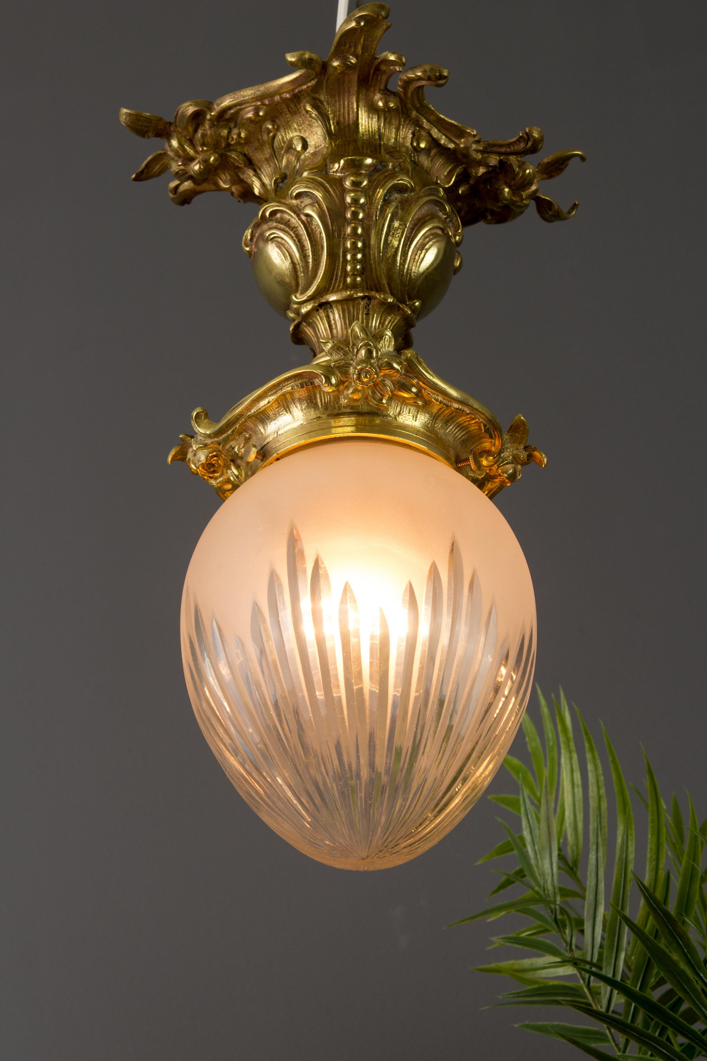 Adorable Rococo or Louis XV style ceiling light. The light fixture is made of bronze and ornate with beautiful Rococo curved decorations - rocailles, leaves, and flowers. White frosted and cut glass shade, one socket for E27 / E26 size light bulb.