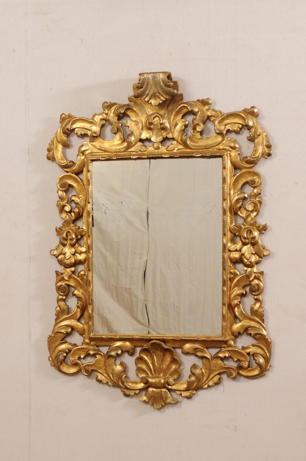 A French Rococo style carved and gilt wood mirror from the 19th century. This antique mirror from France has been designed in the ornate fashion of Rococo style, with a beautifully pierce-carved scrolling acanthus leaf surround, and shell at bottom