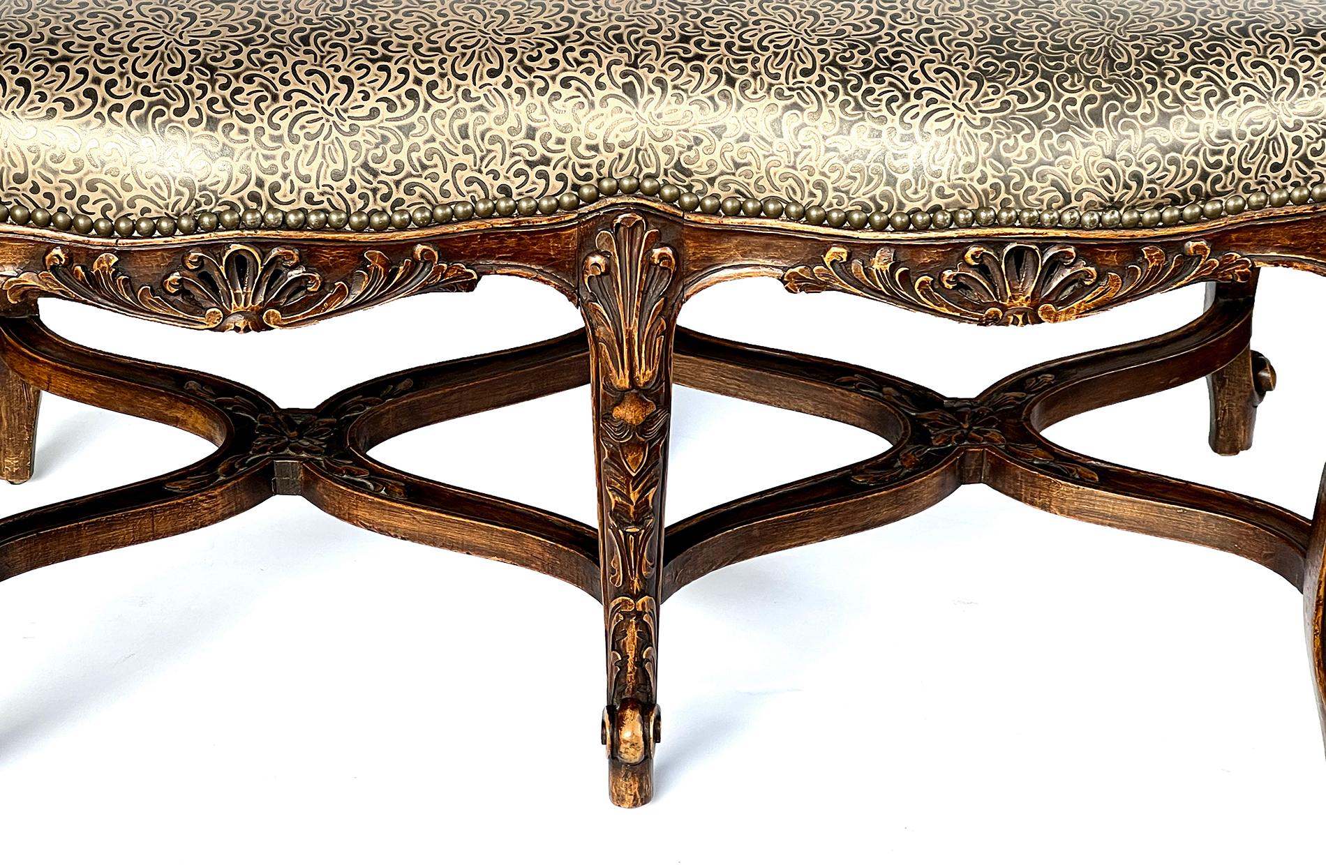 the shaped leather seat above a conforming frame adorned with carved rocaille and foliate motifs all raised on cabriole supports joined by an undulating stretcher