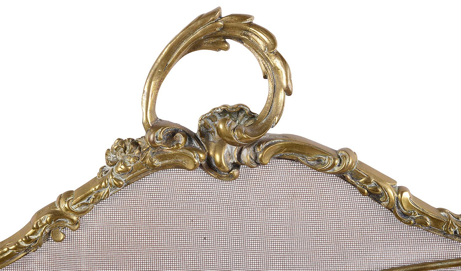 A good quality late 19th century French ormolu Rococo style fire screen, having scrolling foliate decoration, with mesh and raised on out swept feet.
