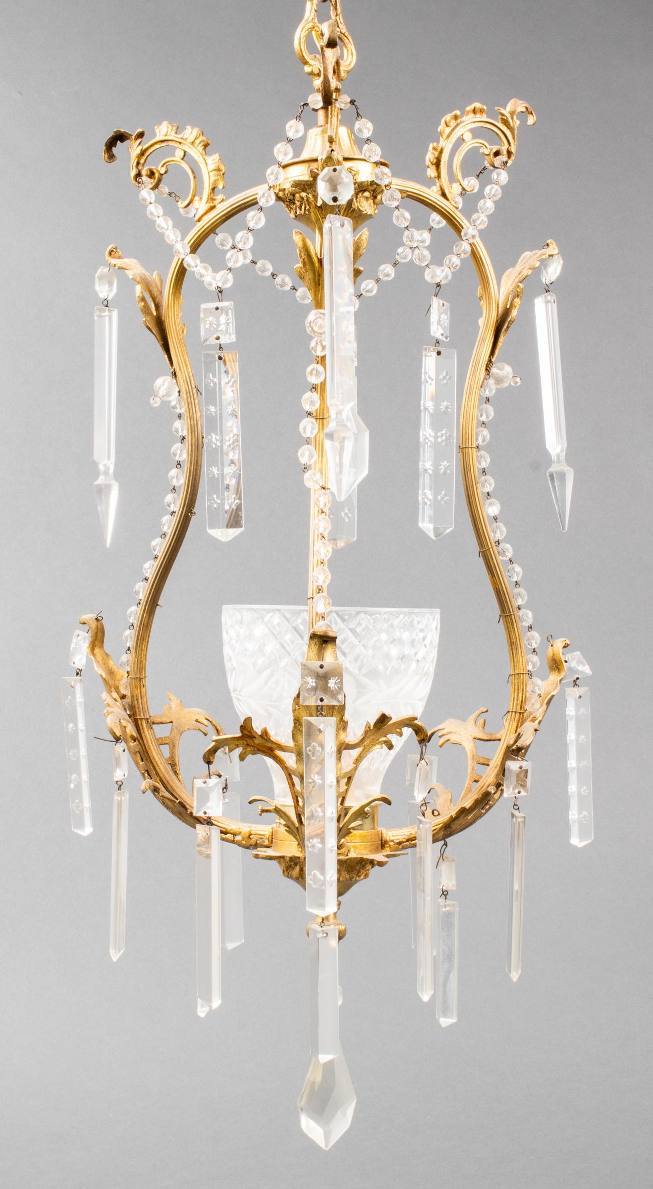 French Rococo style gilt brass and crystal pendant, with central cut crystal shade within brass frame with scrolled acanthus leaf motifs. Measures: 30