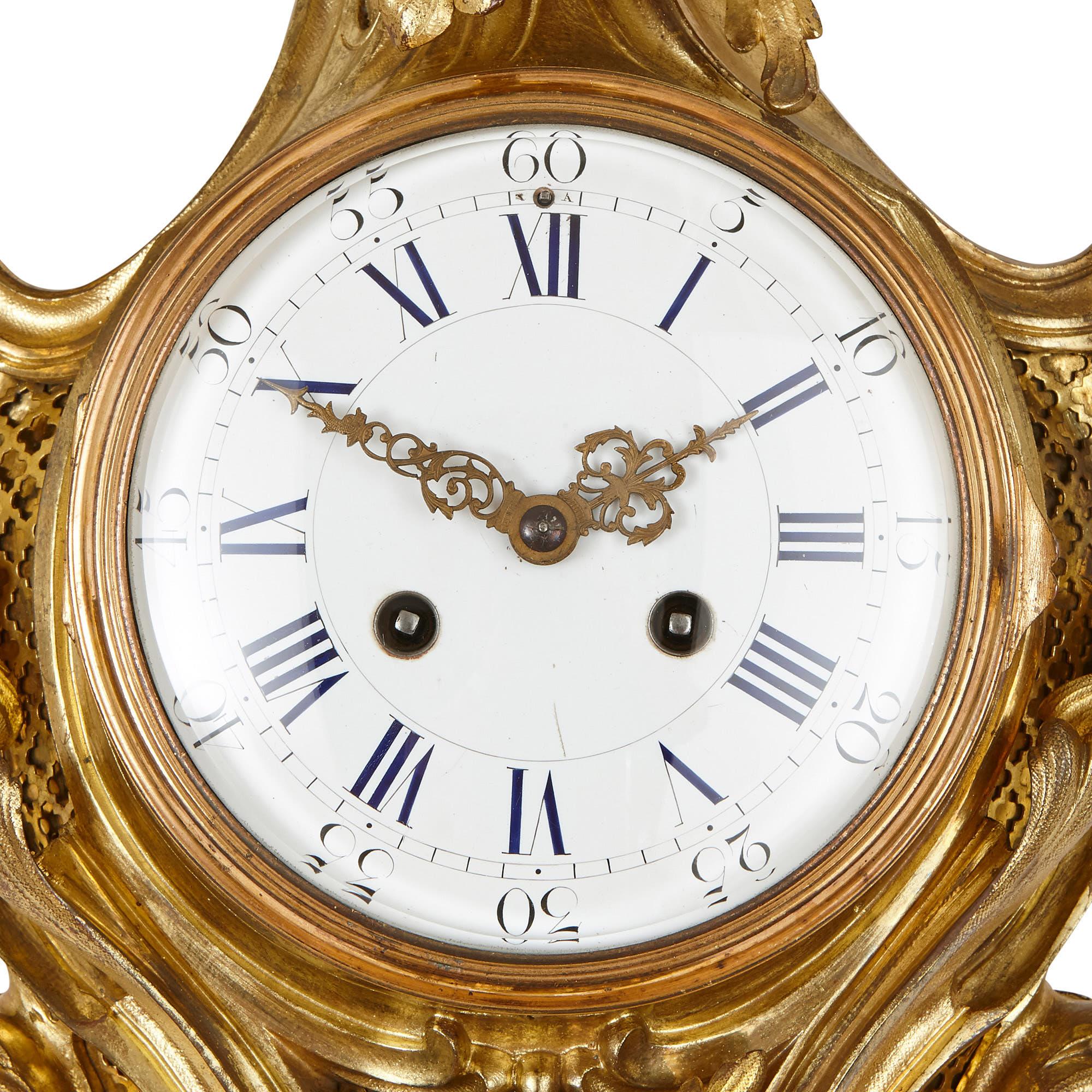 Designed in the French Rococo style, this clock and barometer set have been beautifully ornamented with scrolling foliate gilt bronze forms. The two are diamond shaped, with symmetrical bodies composed of a pointed top and bottom and two flicking