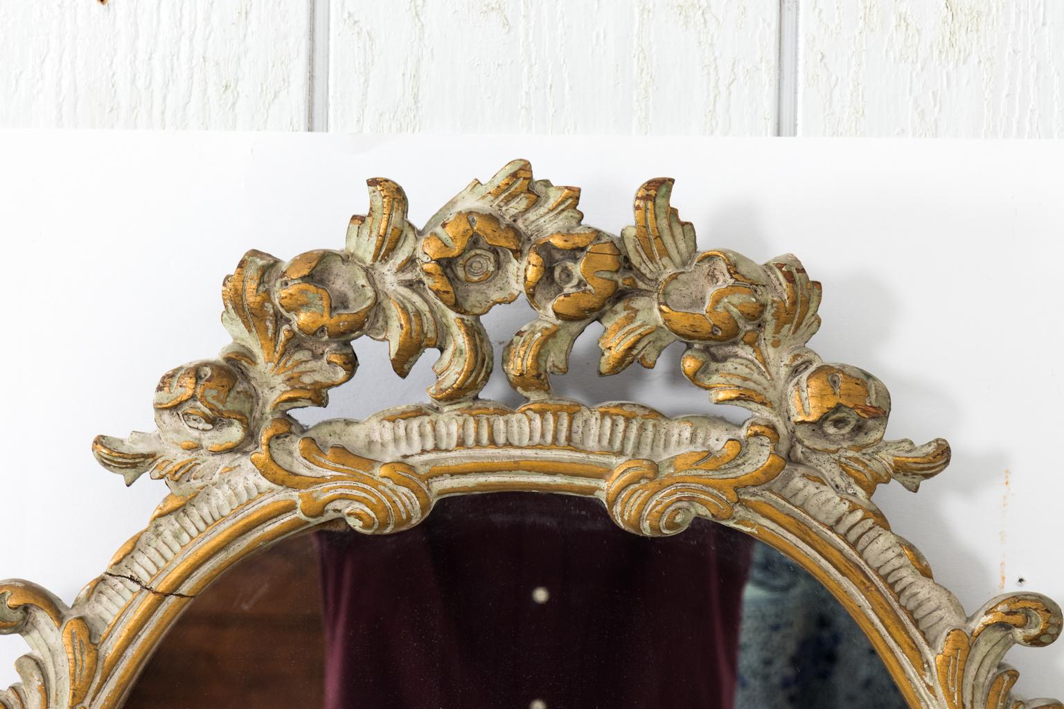 French Rococo style giltwood mirror with hand carved floral detail. Please note of minor wear including a crack in the wood on the top left corner.
  