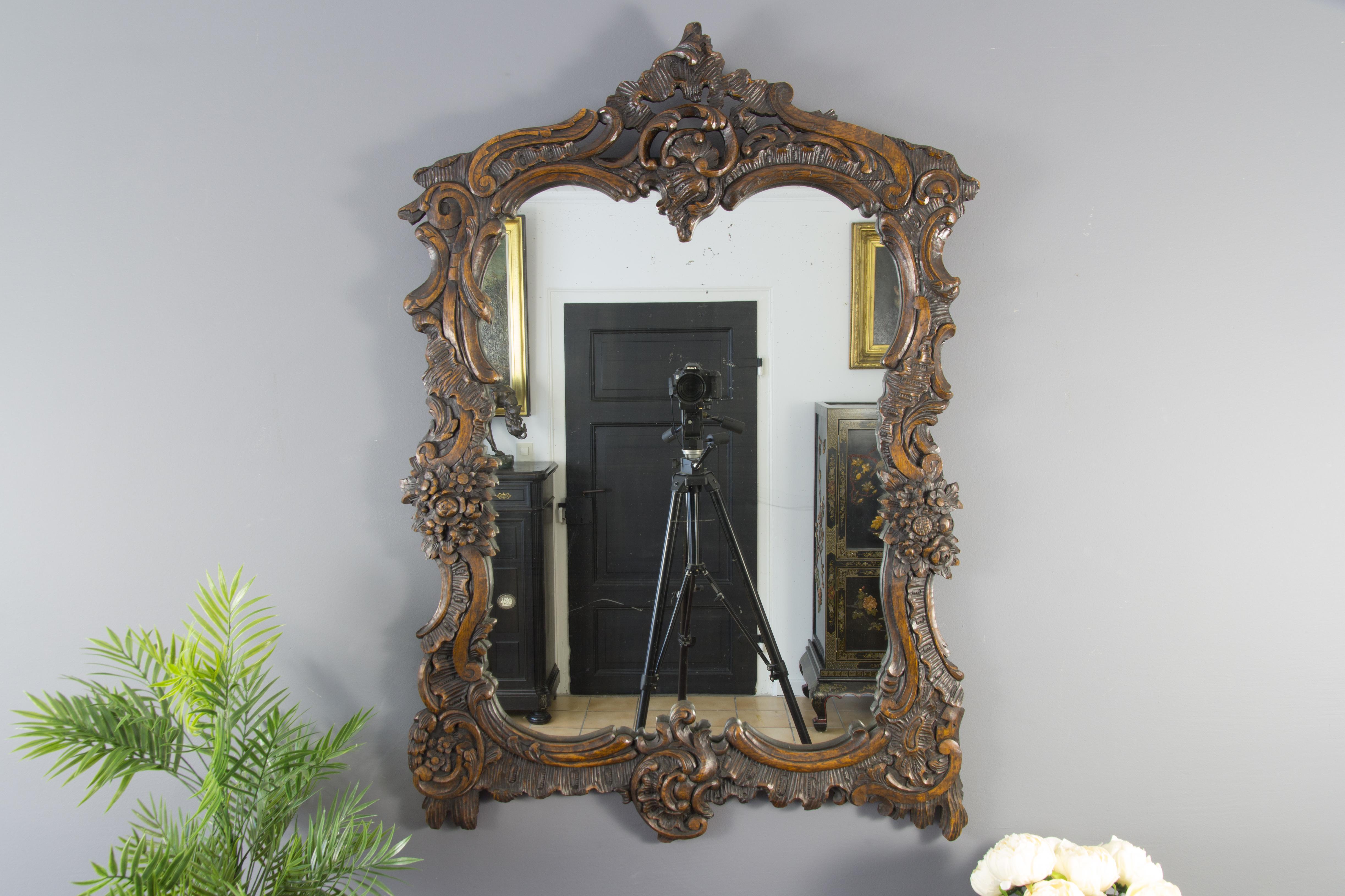 Beautiful large French Rococo or Louis XV style hand carved wood wall mirror, richly ornate carvings with C scroll, rocaille and floral motifs, early 20th century.
Dimensions: Height 118 cm / 46.45 in, width 83 cm / 32.67 in, depth 3 cm / 1.18 in.