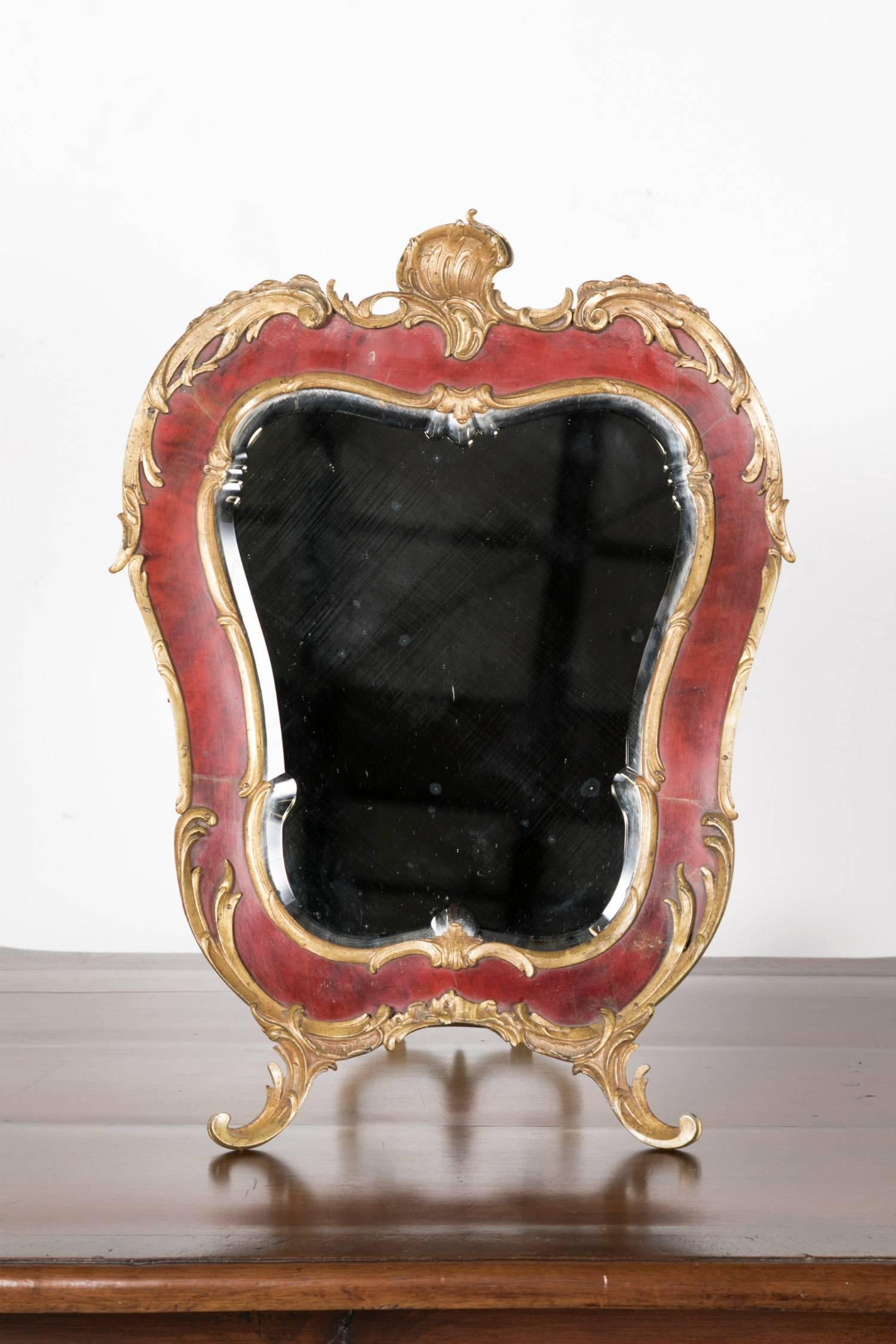 Stunning 19th century French Rococo style red tortoise shell and gilt bronze footed vanity mirror with easel back having the original bevelled glass. This freestanding boudoir mirror features stylized shells and acanthus leaves. Suitable for a