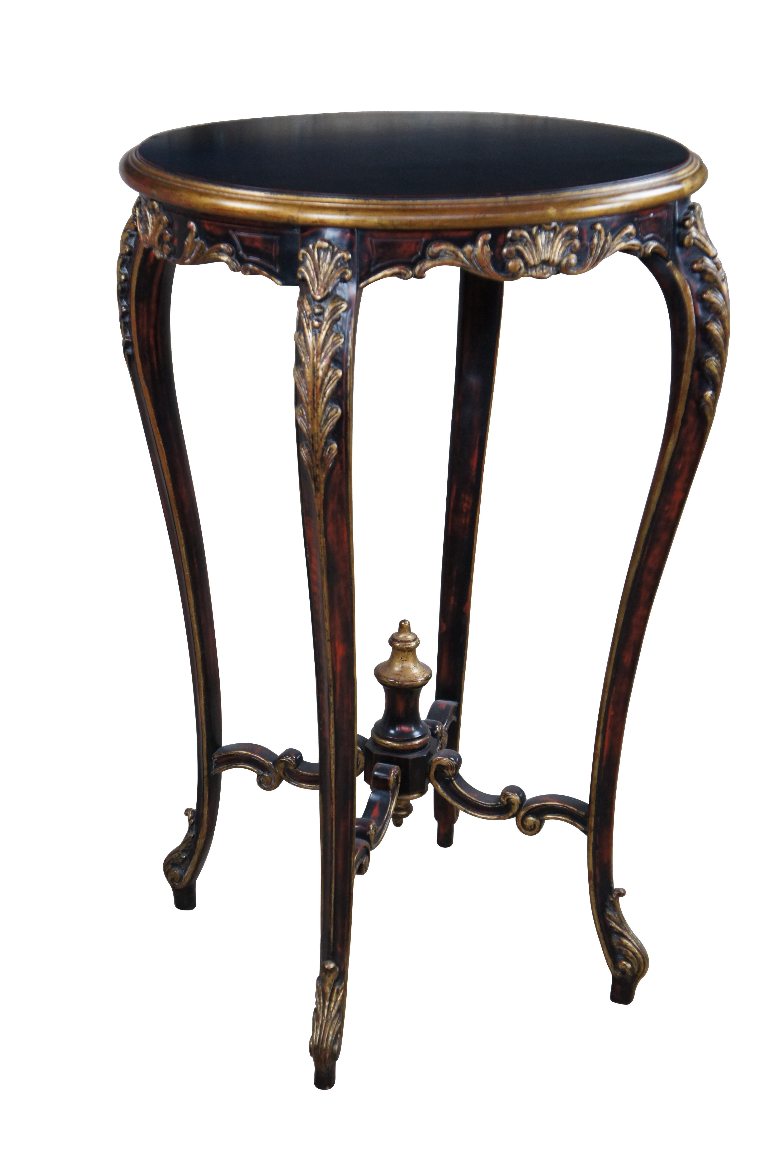 Guéridon vintage de style rococo français avec une forme allongée de Guéridon.  Le plateau ovale est soutenu par des pieds cabrioles rehaussés de feuilles d'acanthe dorées, et reliés par des supports à volutes C.I.C. menant à un fleuron en forme de