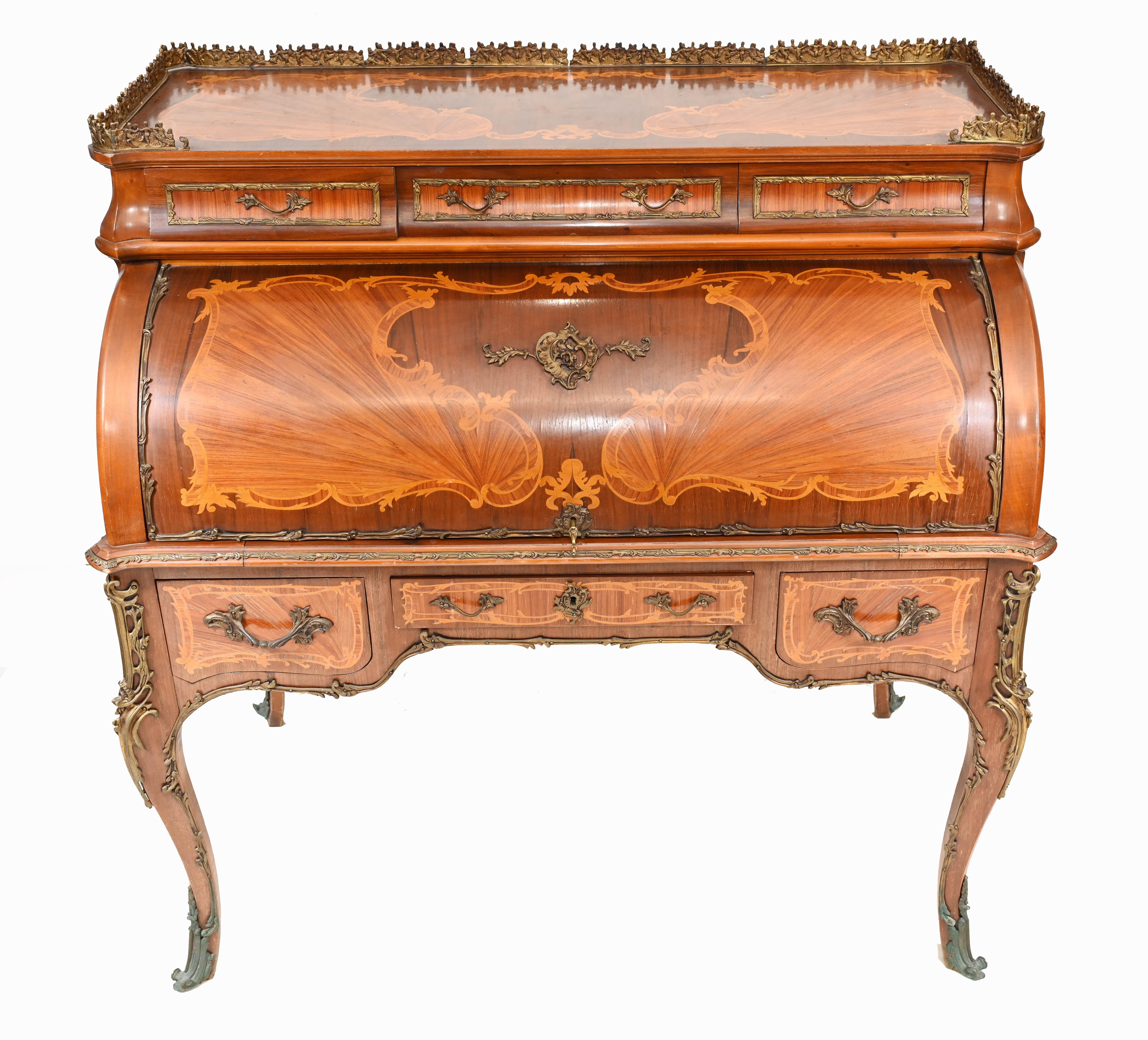 Stunning antique French roll top desk in the Louis XVI manner
Main structure of desk is in kingwood with exotic fruit inlays
Ormolu fixtures are also original and well cast
Desk opens out to reveal all the cubby holes, drawers and the leather
