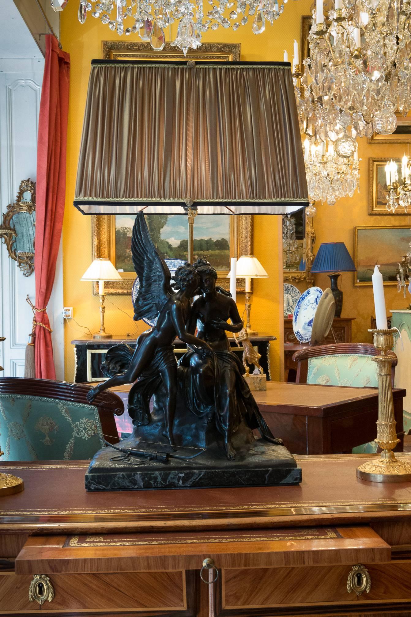 A beautiful finely chiseled and patinated bronze group, depicting an annunciation symbolized by an angel having put down his quiver and its bow to the feet of a nymph seated on a hillock, raised on a base of sea-green marble.

Our sculpture