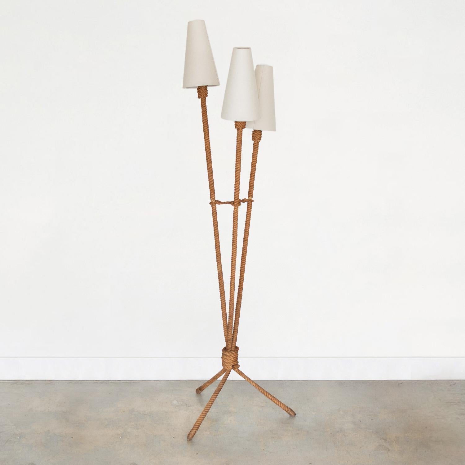 Incredible rope floor lamp by French designers Adrien Aduoux and Freda Minet. Tripod base and three arms with new linen cone shades. Original rope shows great patina and age. Newly re-wired. Takes 3 E12 base bulbs, 40 W or higher using