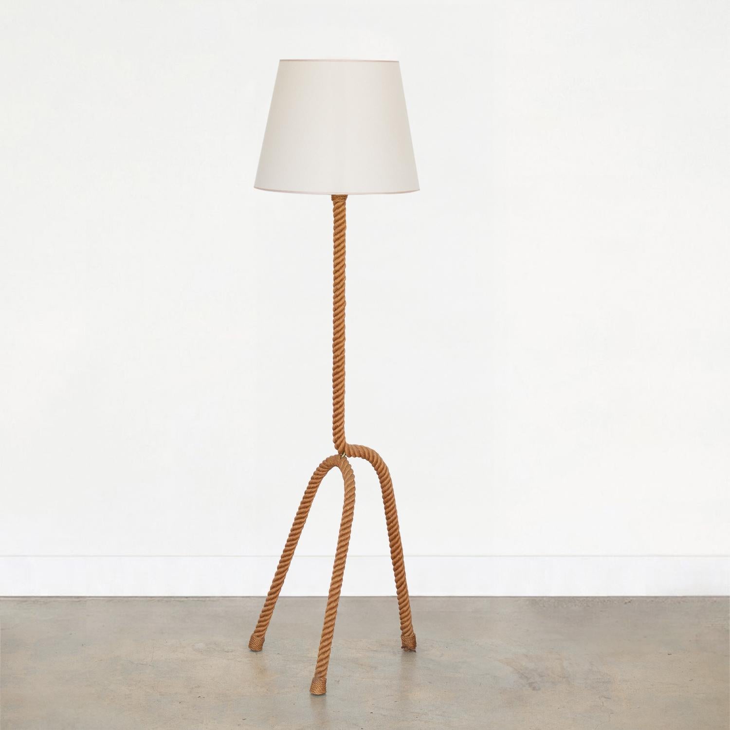 Incredible rope floor lamp by French designers Adrien Audoux and Freda Minet. Beautiful tripod base and stem in wrapped rope. New tapered linen shade with tan trim detail and newly re-wired. Original rope shows great patina and age. Takes one E26