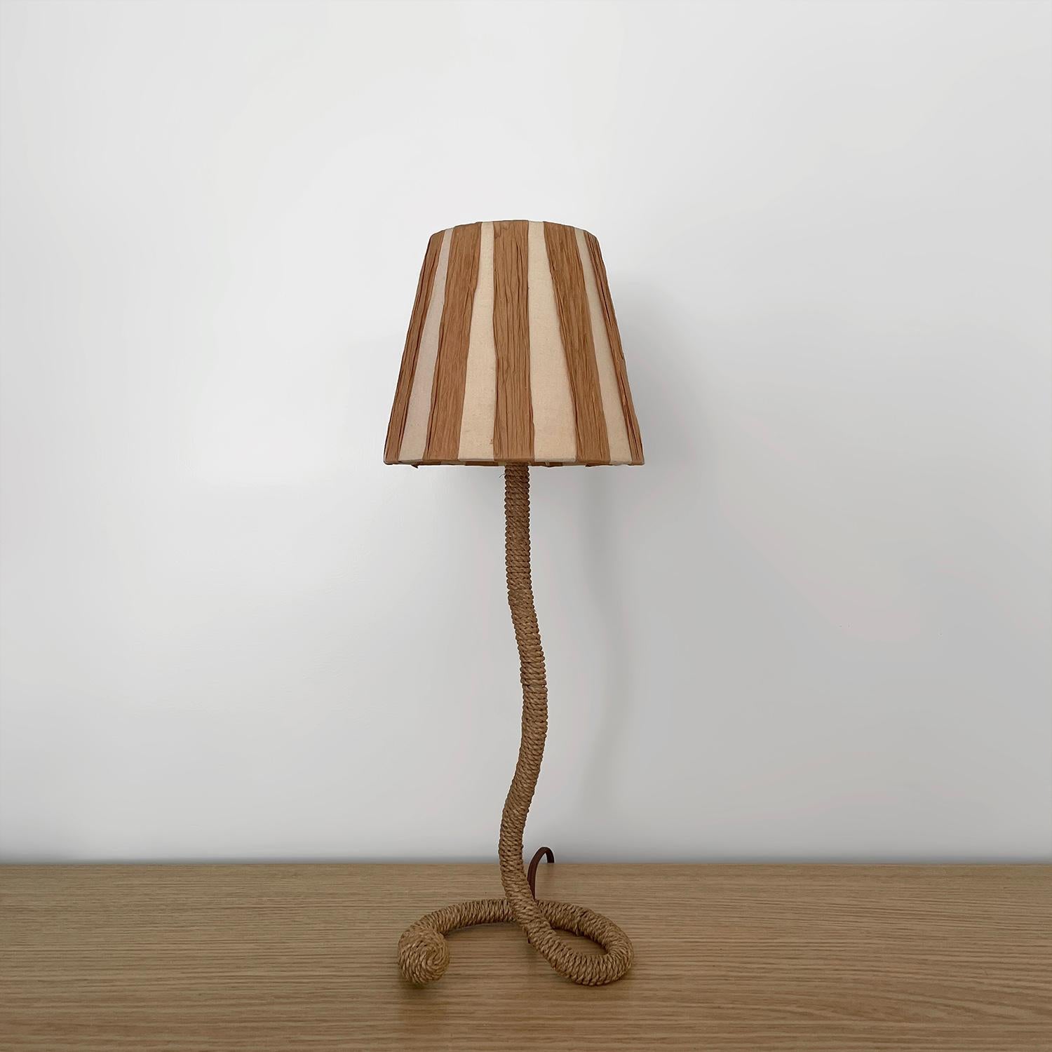 Lampada francese in corda con paralume a righe nello stile di Audoux Minet
Francia, metà secolo 
Una corda delicatamente avvolta avvolge il grazioso stelo della lampada.
Base a forma di ferro di cavallo a spirale rifinita con dettagli a forma di