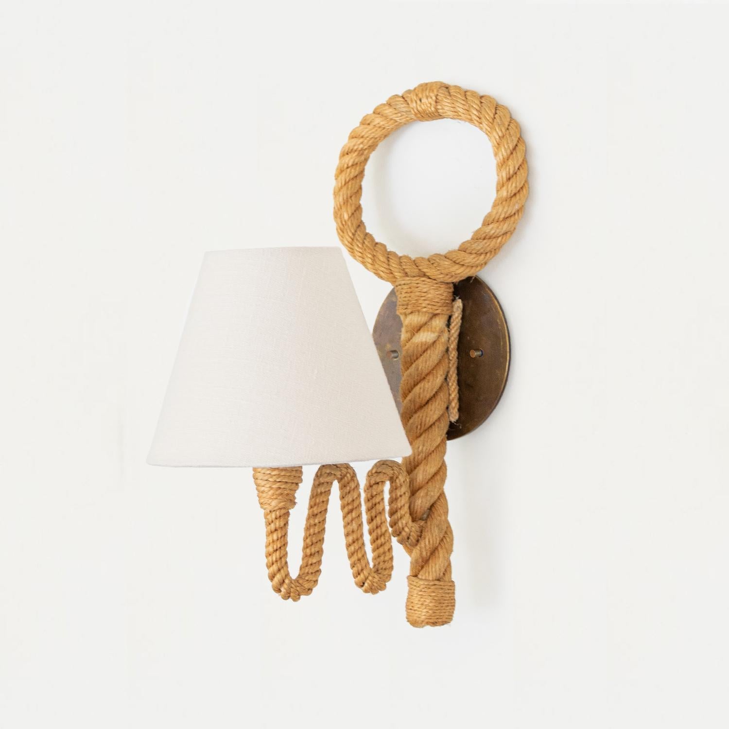 Unique vintage French rope sconce by French designers Adrien Audoux and Frida Minet. Thick twisted rope stem with wavy rope arm extending to hold single socket and shade. Large loop detail on back with new circular brass backplate and new