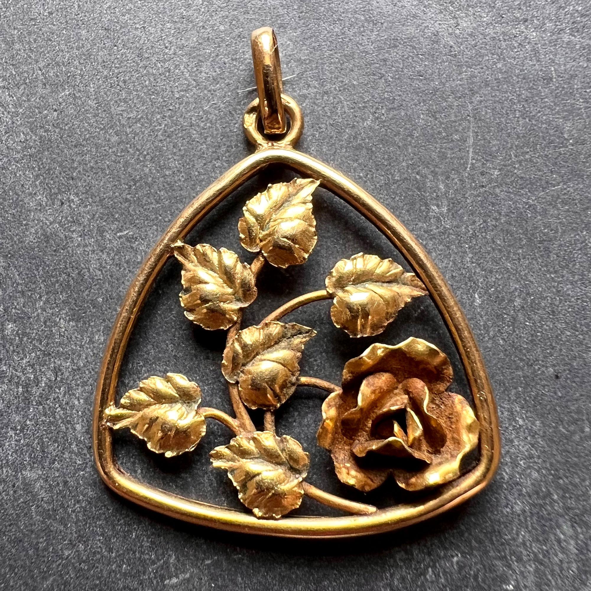 An 18 karat (18K) yellow gold charm pendant designed as a rounded triangular frame containing a realistically modelled rose. Stamped with the eagle’s head for French manufacture and 18 karat gold and an unknown makers’ mark.

Dimensions: 2.5 x 2.3 x
