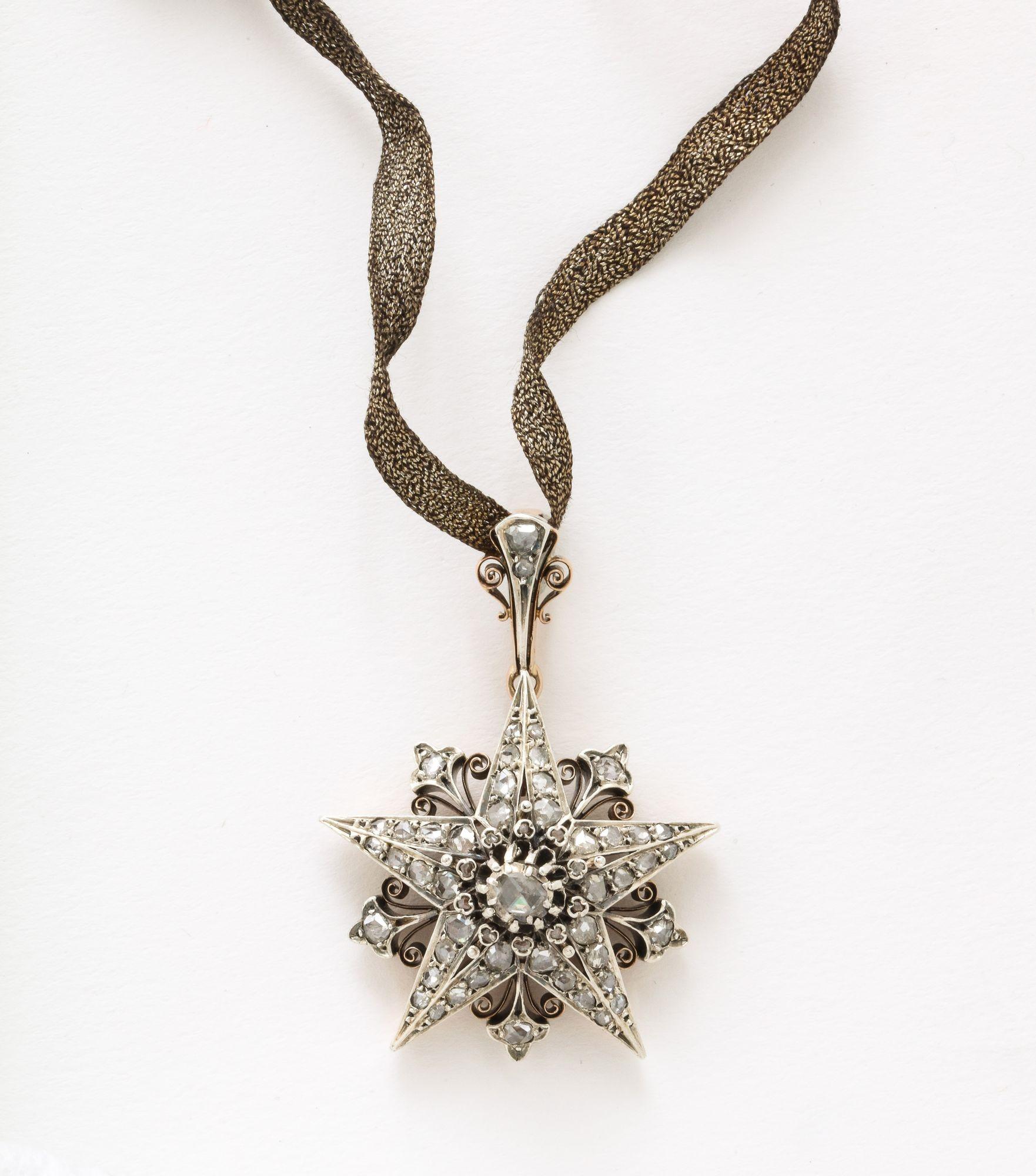 A stunning French Rose Diamond Five Pointed Star Brooch/ Pendant in silver topped 18 k gold with clip sits over a pentangle. The central larger diamond is surrounded with a group of 59 smaller set rose cut diamonds. 2.00 cts Color H-I-J Clarity SI
