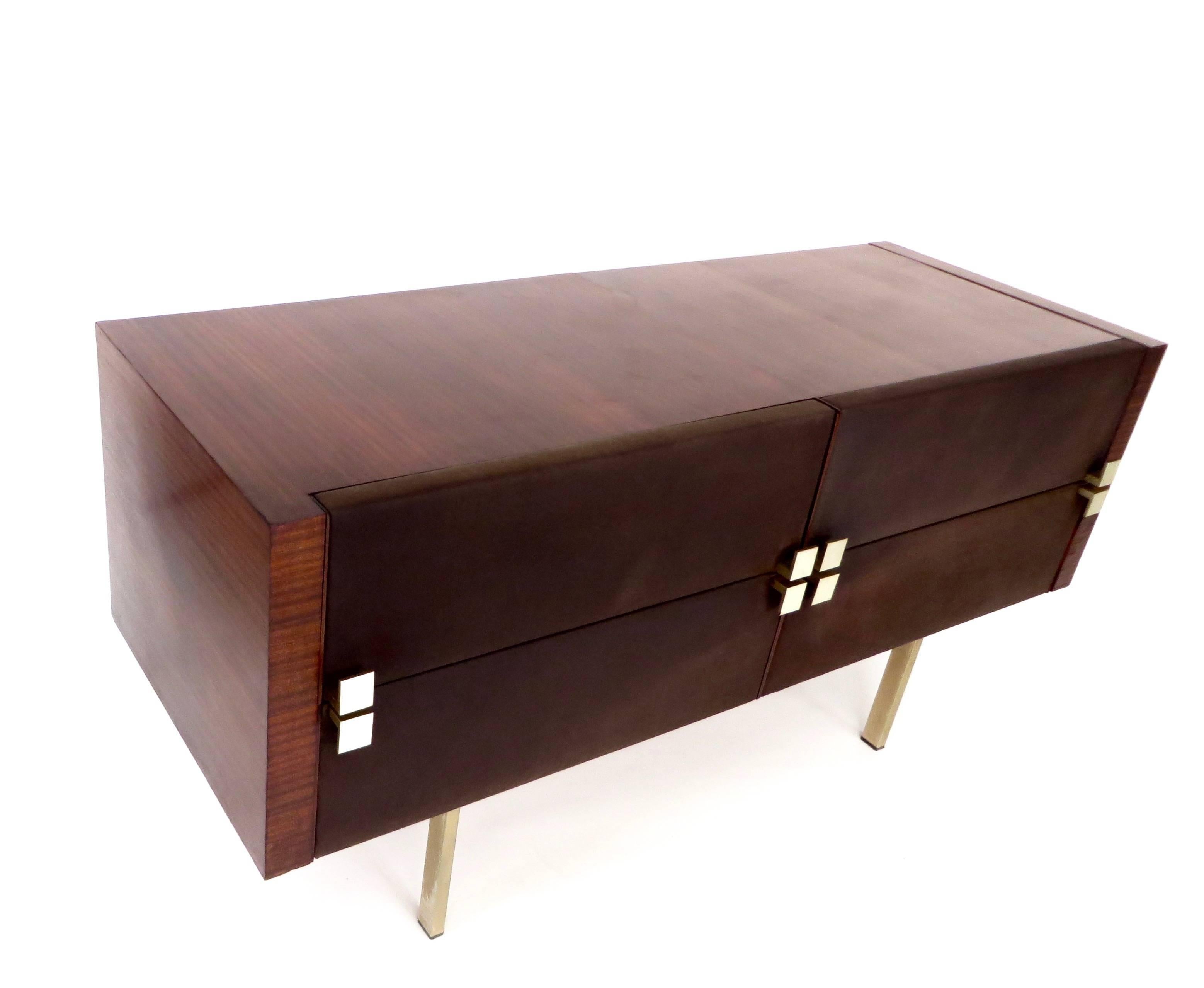 A French modernist cabinet vanity dresser or dressing table by Roger Landault featuring a body in figured rosewood with brass legs and bronze pulls as well as upholstered fronts done in a brown leather.
The cabinet also features three drawers as