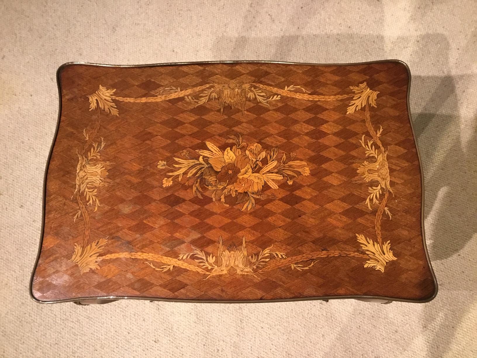 A beautiful French rosewood and marquetry 19th century antique side table. Having a serpentine rosewood parquetry top with fine floral marquetry inlaid detail with ormolu moulding. The front again having a rosewood parquetry inlaid concealed drawer,